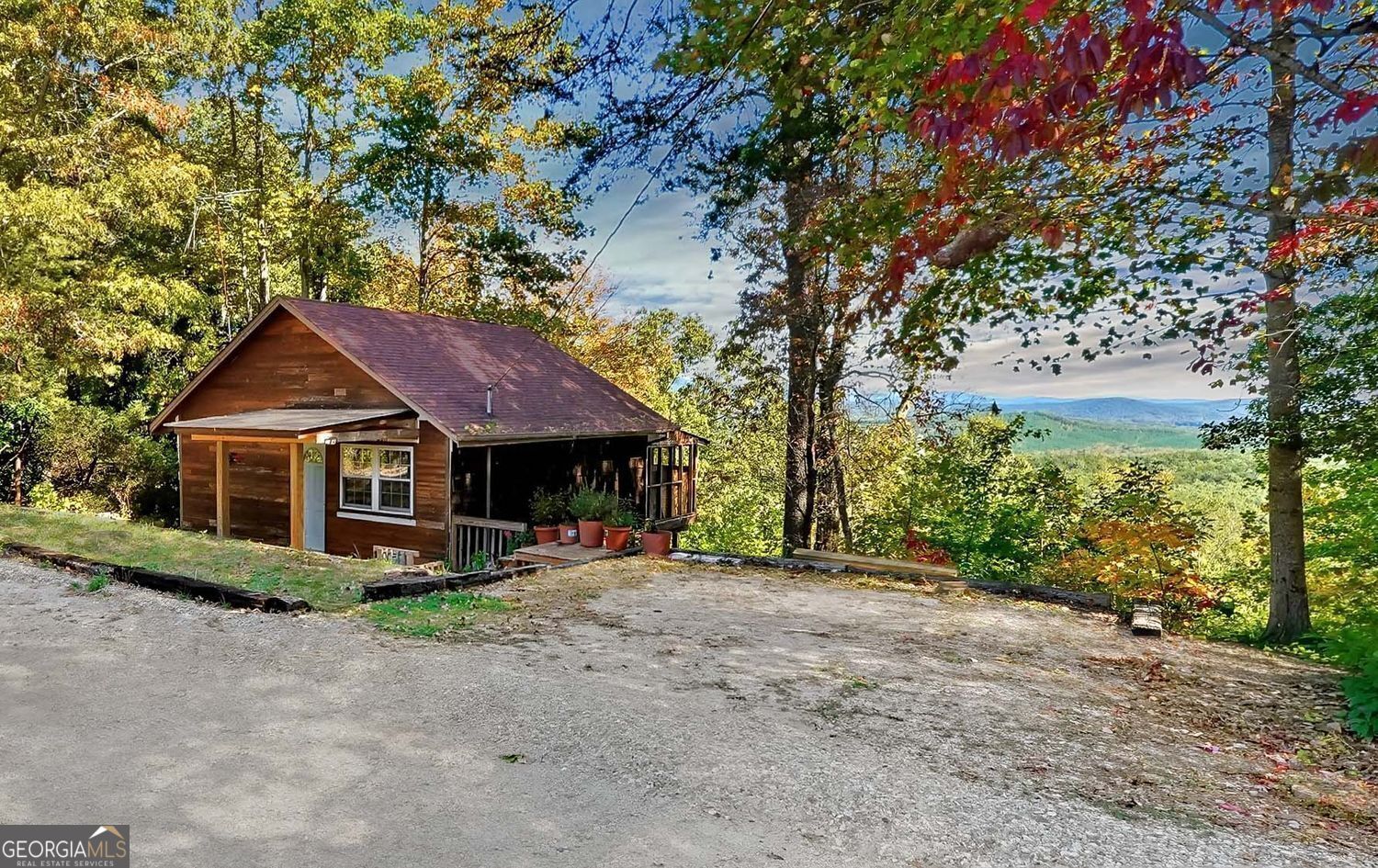 Enjoy stunning long-range mountain views from this charming cabin set on a quiet gravel road that's easily accessible from Hwy 136-no steep roads to climb and a completely level driveway with parking for two cars! Located half-way between Dawsonville and Jasper and set almost a mile from Hwy 136, the only sounds you'll hear here are the eagles and the breeze coming through your screened porch. At 1499 Eagle Ridge Road, you'll wake up every morning to panoramic mountain views right from your bedroom, which you can also enjoy from your back deck, the kitchen, the living room, the second bedroom, and your other back deck! With a completely open floor plan and windows along the length of the home, this would make the perfect full-time home with plenty of room for entertaining, a weekend getaway, or an Airbnb. The main floor features vaulted ceilings, wood floors, a brick fireplace, and oversized sliding glass doors opening to one two 24' wide covered decks. The lower level offers two bedrooms (one with a second brick fireplace), a full bath, an additional bonus room perfect for an office or studio, as well as a second 24' wide covered deck! Rare opportunity to get a panoramic mountain view at this price point. Backs up to thousands of acres of DNR property providing longterm privacy! Home needs some TLC and renovations.