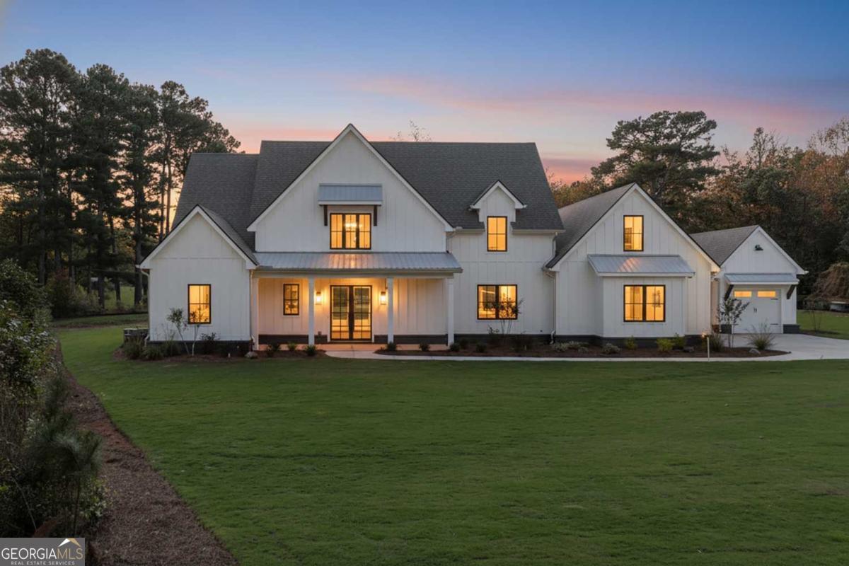 ** READY NOW ** Welcome to this stunning NEW CONSTRUCTION home, nestled on a level and private 0.92-acre lot in an exclusive enclave of just five custom homes in an A+ Woodstock location. With a striking elevation and impeccable curb appeal, this residence offers refined luxury, thoughtful design, and energy-efficient features throughout.  Step inside from the covered front porch to a vaulted family room anchored by a beautiful fireplace, featuring  custom built-in cabinets and floating shelves on each side. A spectacular 16-foot sliding glass door opens to a spacious covered rear patio with its own cozy fireplace-ideal for entertaining or quiet relaxation while overlooking the private, level backyard, perfectly suited for a future pool.  The main level features a luxurious primary suite with a spa-inspired ensuite bath, showcasing a zero-entry shower, designer tile, quartz countertops, and dual custom walk-in closets. A separate guest suite with its own zero-entry bath, a large laundry room, and a well-designed mudroom add everyday convenience.  The gourmet kitchen is a showstopper with an oversized island, quartz countertops, a slide-in range, abundant cabinetry, and a separate dining or breakfast room for effortless entertaining. A stunning switchback staircase leads to the second floor, where you'll find two spacious bedrooms, each with its own ensuite bath, and a versatile bonus room perfect for a den, office, or playroom.  Built with comfort and efficiency in mind, this home includes spray foam insulation, a tankless water heater, high-efficiency HVAC, and low-maintenance vinyl windows. Every corner reflects quality craftsmanship and luxurious detail-this is Woodstock living at its finest.