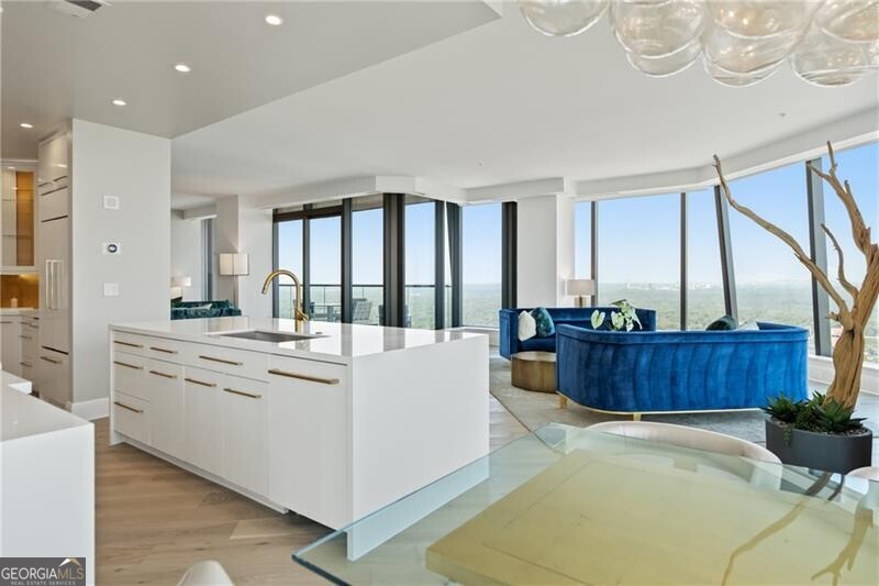 Perched high above Atlanta on the 42nd floor of Sovereign, one of the city's most prestigious residential towers, this fully remodeled residence showcases a sought-after floorplan with three private balconies and breathtaking skyline views. From the solid new hardwood floors to the designer lighting, every detail has been thoughtfully curated. The open-concept design seamlessly connects the living room, den, and dining areas to the expansive chef's kitchen, featuring WOLF, Thermador, and Sub-Zero appliances, pearlized cabinetry, quartzite countertops, and striking Onyx backsplashes. A custom wet bar with glass-front cabinetry, downlighting, and a Thermador beverage center with storage for 44 bottles makes entertaining effortless. The spacious primary suite offers customized dual closets and its own private balcony, while the spa-inspired bath boasts marble floors and shower, a soaking tub, and new dual vanities. The guest suite includes a large walk-in closet, newly designed bath, and private balcony access. Even the powder room delights with a bespoke vanity and lighted art niche. Additional features include three assigned parking spaces and a generous climate-controlled storage room. Living at Sovereign means enjoying unmatched services and amenities, including 24-hour concierge, valet parking, onsite management, private entertaining and lounge spaces, a conference room, wine lockers, Skydeck with zero-entry saltwater pool and hot tub, outdoor grilling stations with WOLF grills, and a state-of-the-art fitness center with private training rooms. All of this is just steps from Atlanta's finest shopping and dining-Lenox Square, Phipps Plaza, Shops Around Lenox, and award-winning restaurants including Bistro Niko right next door. Don't miss the opportunity to experience luxury living at its finest-schedule your private showing today and see why Sovereign is the ultimate address in Atlanta.