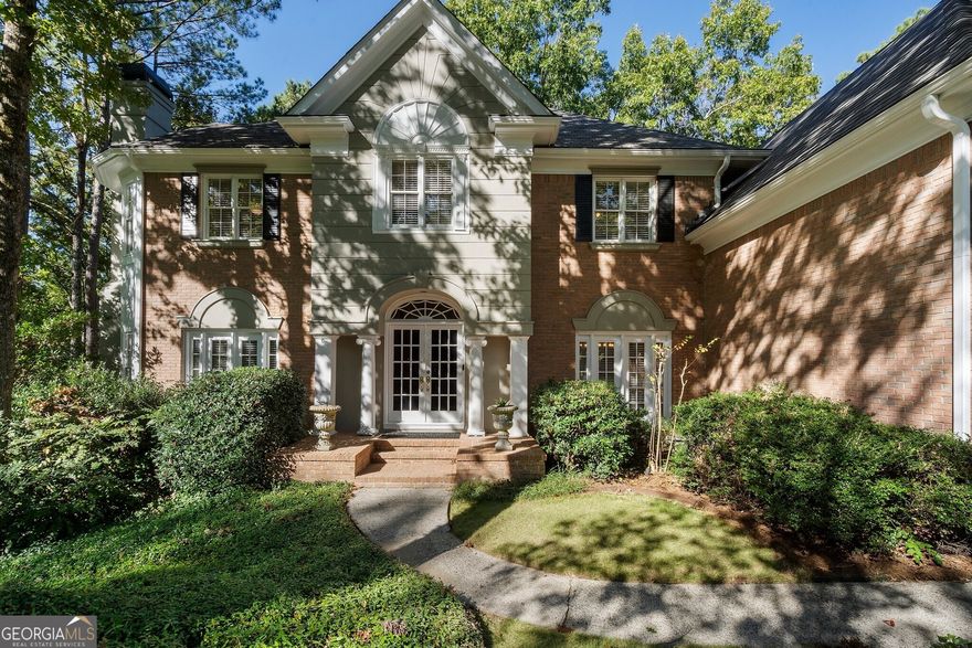 This stunning home, located at the end of a serene cul-de-sac in the Nesbit Lake Community, offers privacy and curb appeal. As you enter through the charming French doors, you're immediately drawn in by the impressive stonework in the entryway and elegant crown moldings. To your right from the foyer, the formal dining room is perfect for hosting dinner parties and also offers convenient access to the kitchen. Directly across the foyer is the formal living room, featuring a striking mantel and cozy fireplace. A private service bar bridges the living room and the den, making it an ideal setup for entertaining guests. The den exudes warmth, highlighted by an inviting fireplace and two sets of French doors that lead out to the back patio, where breathtaking views of the lake await. An informal dining area that can be used as a breakfast nook seamlessly transitions into the chef's kitchen. This kitchen features; a large island, high-end stainless steel appliances, tons of counter space, and a beverage fridge.  For added convenience, the laundry room is located on the main floor. Ascending the grand staircase, you'll notice the meticulous details, including built-in display spaces lining the walls. At the top of the stairs, you'll find the oversized primary suite, with a spacious, fully remodeled bathroom and generous custom closets. The luxurious spa-like bath boasts a beautiful stone and tile shower, stone countertops, and a luxurious soaking tub. Down the hall, there's a library and office featuring a fireplace and elegant paneling, making it an ideal space for working from home. You'll also find three spacious guest bedrooms with en suite baths. The fully finished terrace level, complete with a full bath and kitchenette. This versatile space features an extra family room, a TV/game room, and another guest bedroom, alongside plenty of storage options. With direct access to the backyard, it's an ideal retreat. No detail has been overlooked in this remarkable home. Adding to the retreat-like feel, you'll find a dock perfect for fishing in the stocked lake. The community is vibrant, offering access to swimming and tennis, along with kayaking and fishing opportunities. Neighborhood amenities include a clubhouse, six tennis courts, a swimming pool, a splash park, a playground, sidewalks, pickleball courts, and two fire pits.