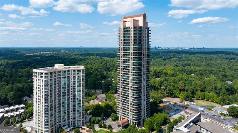 Welcome to this extraordinary penthouse residence, where luxury and comfort blend effortlessly in the heart of Buckhead. Step through the private owner's entrance into the grand salon, an entertainer's dream featuring a full-service bar, card playing area, and floor-to-ceiling windows with stunning southeastern views. A wrap-around terrace invites seamless indoor-outdoor living, perfect for any occasion. Adjacent, a circular formal dining room impresses with its dome ceiling and custom hand-blown glass chandelier. For quiet moments, the library/study offers a peaceful retreat with 12-foot ceilings, rich wood paneling, and a private balcony. The gourmet kitchen inspires culinary creativity with top-of-the-line appliances, expansive countertops, a walk-in pantry, and a custom temperature-controlled wine room. In the primary suite, unwind in a spacious sitting area while taking in panoramic views. The en-suite bathroom offers a spa-like experience, complete with a soaking tub, walk-in shower, and his-and-hers closets. A full guest suite makes visitors feel at home with a seating area, custom closet & en-suite bath. A distinguished Executive Office adds sophistication, while well-appointed live-in home manager quarters w/ full kitchen & bedroom suite enhance the convenience of this luxurious home. Beyond the residence, Park Avenue Condominium offers elite amenities: a heated saltwater pool, state-of-the-art fitness center, 24 hr. security, lobby ambassadors, valet parking & stylish guest suites. Positioned within walking distance of Buckhead's finest shopping and dining, this home delivers an unparalleled lifestyle of sophistication and ease.