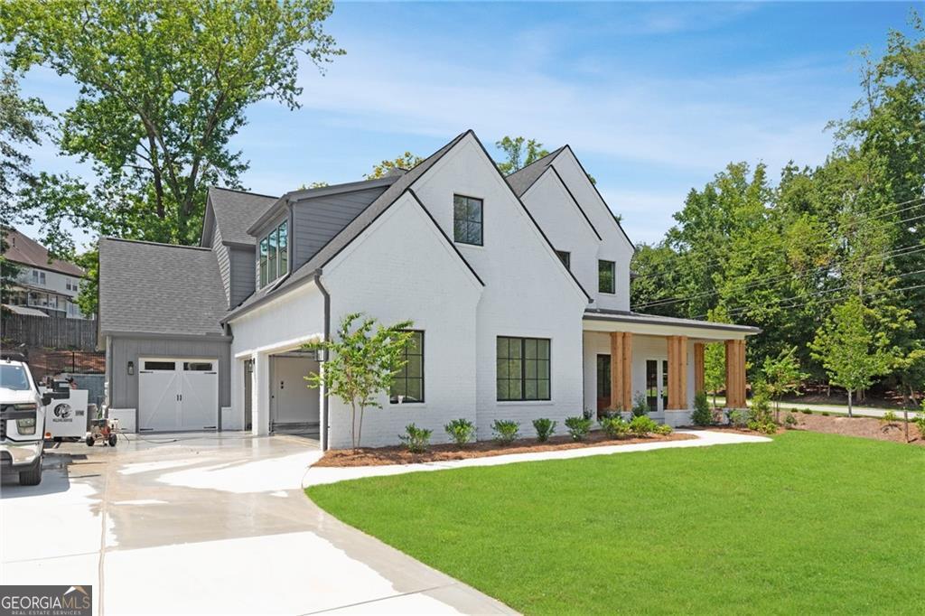 Located in the prestigious Town Farms community of Peachtree Corners, this newly constructed home blends modern luxury with everyday functionality across 5 bedrooms, 5.5 baths, and a 4-car garage. From the moment you step into the dramatic two-story foyer, it's clear that this residence was built with thoughtful design and attention to detail. The main level is designed for both style and comfort, featuring a sun-drenched private office and a formal dining room perfect for hosting gatherings. The chef's kitchen is the true centerpiece-crafted with sleek quartz countertops, high-end appliances, custom cabinetry, and a walk-in pantry. An oversized island anchors the space and flows effortlessly into the fireside family room, where expansive glass doors lead to a covered outdoor lounge with a fireplace-ideal for year-round enjoyment. A guest suite with a private bath, along with a stylish powder room, completes the main floor. Upstairs, the serene owner's retreat features a spa-like bathroom with a freestanding soaking tub, dual vanities, a frameless walk-in shower, and an impressive custom closet. Three additional bedrooms, each with their own bathroom and walk-in closet, offer generous space for family or guests. The conveniently located upstairs laundry room adds to the home's practical layout. Professionally landscaped grounds and a spacious backyard offer the perfect backdrop for outdoor entertaining or quiet relaxation. Just minutes from top-tier amenities like the Atlanta Athletic Club, The Forum, and Peachtree Corners Town Center, this home offers refined living in one of North Atlanta's most sought-after neighborhoods.