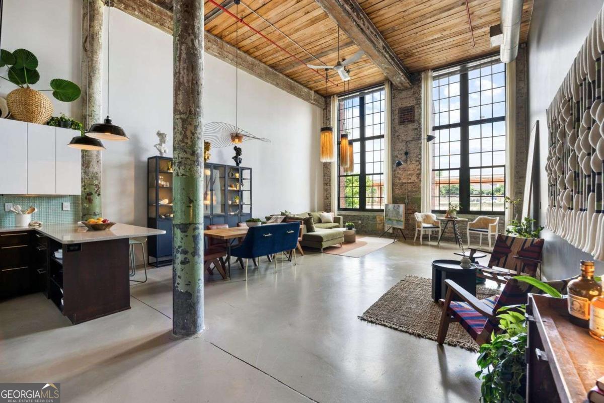 Industrial Elegance with Modern Comfort in this authentic 2-bedroom, 2-bathroom loft at Atlanta's iconic Stacks at Fulton Cotton Mill. Soaring 18.5-foot ceilings, exposed brick, polished concrete floors, and 14-foot factory-style windows flood the space with natural light and frame sweeping views of the Atlanta skyline. The main level features open-concept living, dining, and kitchen areas, plus a full bedroom with custom closets and an adjacent full bath. A large laundry room provides generous storage-ideal for bulk essentials, luggage, or seasonal decor. Upstairs, the second bedroom is spacious and flexible-perfect as a private retreat-and includes its own bathroom and custom walk-in closet. Recent upgrades and highlights include: New kitchen appliances, including stove and dishwasher New hardwood floors upstairs New water heater (2023) All appliances, including washer/dryer, remain with the unit Two deeded parking spaces Access to four EV charging stations The gated community offers resort-style amenities: pool, fitness center, rooftop terrace, dog park, and more-just minutes from the BeltLine, top restaurants, and Atlanta's favorite intown destinations. HOA includes exterior maintenance, pest control, trash service, and pool access. Live in history. Entertain in style. Soak up the city.