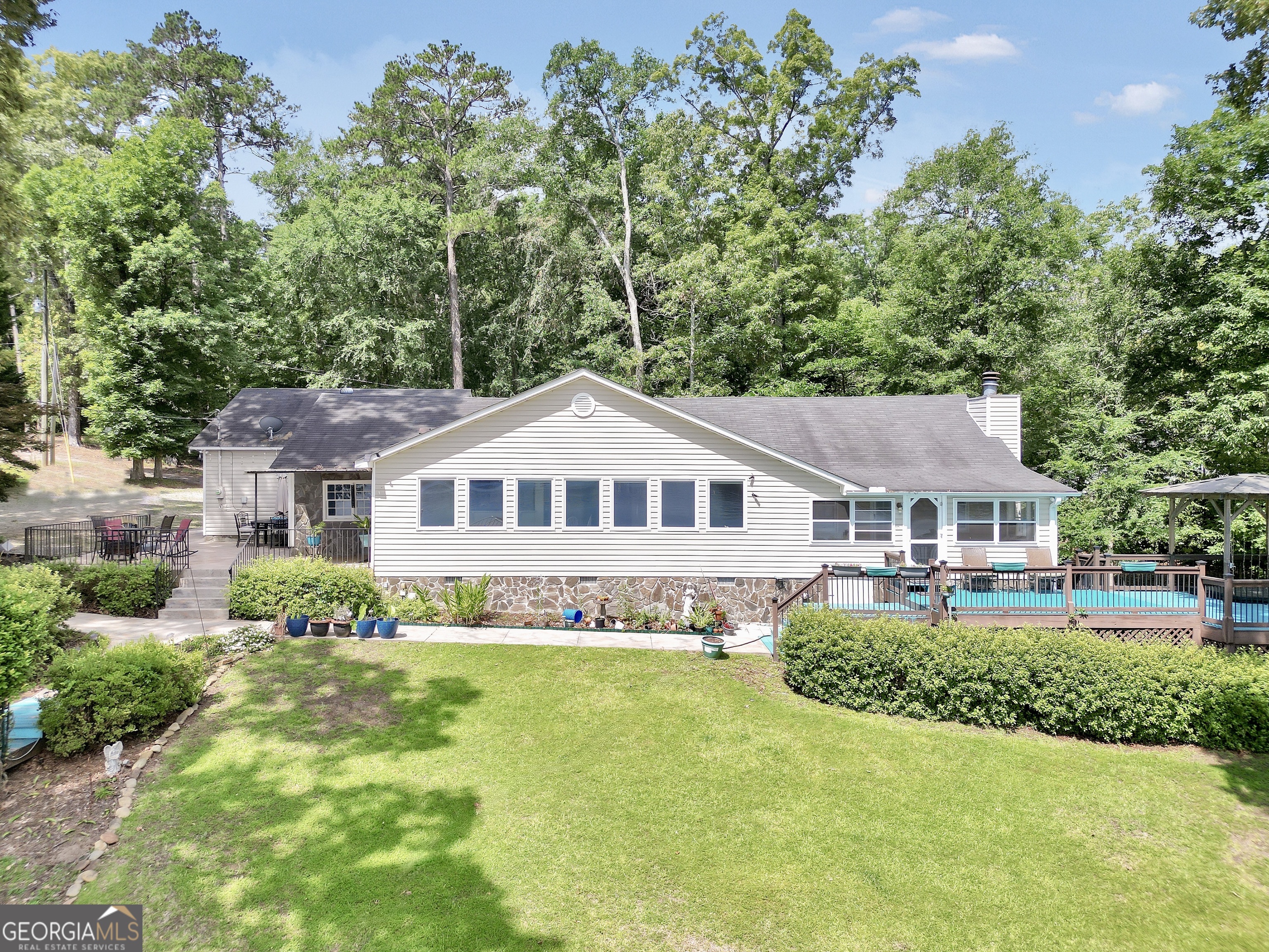 Million Dollar Views Without the Price Tag - Lakefront Living at Its Finest! 172B Hummingbird Ln, Jackson, GA | $729,000 | 3 Bed * 2 Bath * Jackson Lake Welcome to 172B Hummingbird - your perfect lakefront retreat on beautiful Jackson Lake! This impeccably maintained 3-bedroom, 2-bath home offers breathtaking panoramic views and over 200 feet of deep water frontage on a Georgia Power lease lot - all for just $729,000. Step inside and enjoy the thoughtfully updated interior, featuring a modern kitchen with granite countertops, newer appliances, and luxury vinyl plank (LVP) flooring throughout the main living areas. Two cozy bedrooms offer carpet underfoot, while the expansive master suite is a true sanctuary with stunning lake views, a wood-burning fireplace, walk-in closet, and a spa-like updated bathroom. Step directly from the master suite into the sunroom-perfect for morning coffee or relaxing evenings. The spacious living room showcases a wall of windows with pull-down shades, framing an unbeatable view looking up toward the 212 bridge. Outside, entertaining is effortless: Stone patio with built-in fire pit, Deck with newer 6-person hot tub and lake views, Lakeside firepit area in the yard, Double-slip stationary dock with sun deck, two lifts, storage closet, and fish cleaning station, Private boat ramp, 14 ft deep water at the back of the dock. Additional features include a 2-car attached garage, separate storage shed, high-speed internet via Conexon, and a full security system for peace of mind, lawn irrigation system. This is more than a home - it's a lifestyle. Whether you're looking for a full-time residence or a weekend escape, 172B Hummingbird delivers luxury, privacy, and the best of Jackson Lake living. Don't miss this rare opportunity - schedule your private showing today!