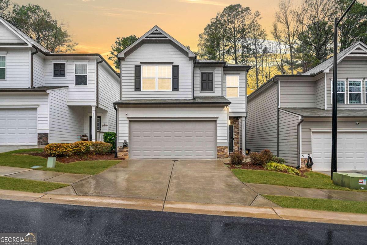 Modern Craftsman Style Home, built in 2020. The front porch sets the tone for this inviting residence. Inside, the open-concept living welcomes you into a bright and airy space. The kitchen features white cabinetry, stainless steel appliances, granite countertops, a breakfast bar, and a pantry. Off the kitchen is a dining area and a large family room with a cozy fireplace. Upstairs, a spacious loft provides opportunity for an office nook or flex space. The primary suite features trey ceilings and an oversized en suite bath featuring a soaking tub, walk-in shower, double vanities, a water closet, and a spacious walk-in closet. Two additional bedrooms share a full bath. Step outside onto the deck overlooking a private, fenced backyard that backs up to lush green space, offering a peaceful retreat. Located in the Etowah High School District. Close to Lake Allatoona, shopping and restaurants.