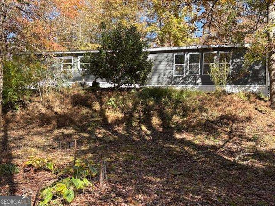 There's plenty of Room in this home, which sits on a beautiful 1.91-acre lot, with two branches. This home has been remodeled. The home is a large 28x65 Franklin 1991 mobile home. It has been added on to, making it quite a bit larger than tax records show. The Kitchen is huge with new cabinets. You could fit a big family table! The current owner uses the dining area as part of the massive living room, which has a stone fireplace. He has turned one of the bedrooms into a side entry room from the driveway; it can easily be turned back into a bedroom. Part of the addition has a wall of windows overlooking the Stream, This room is used as a sunroom . The rest of the addition could be used for an extra bedroom/closet. The exterior and the interior have been newly painted. All new flooring throughout the home. The home is still being worked on. Down by the little creek is a fire pit, making it a sweet place to get away to or have family gatherings. A good potion near the creek is level. Two streams run together on this tract.   Hill city school district.