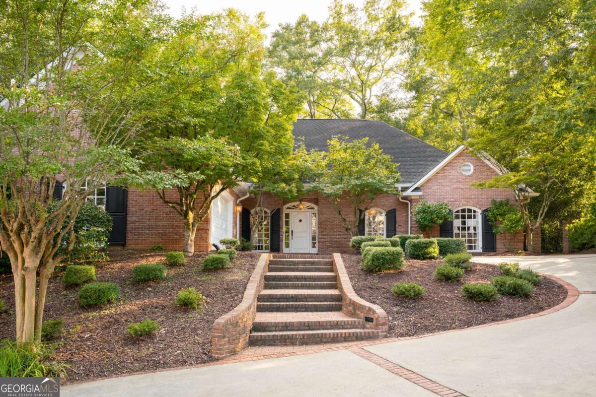 Located in the Princeton Mill neighborhood of the sought-after Five?Points area, this classic brick home has all the Southern curb appeal you could dream of. Inside, hardwood floors run throughout, complemented by detailed millwork and trim. A traditional foyer opens to a living area flanked by arched windows that bring in beautiful natural light. The formal dining room is perfect for gatherings, and the spacious kitchen overlooks the breakfast room. French doors lead to a large brick back porch that naturally extends the living and dining space outdoors, accented by classic Chippendale railing. The layout offers easy, one-level living with three bedrooms, two full baths, a generous laundry room, and an attached two-car garage. Don't miss this gem of a house. With a little love, it will be a show-stopper.