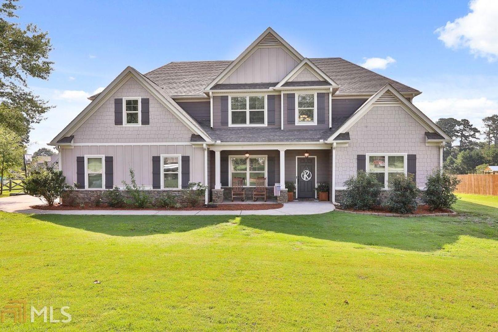You'll want to see this Gorgeous 5 Bedroom, 3.5 Bathroom Craftsman Home on 1.65 Acres in Beautiful Senoia! Main floor features hardwood floors throughout. The elegant formal dining room with coffered ceiling, wainscoting, built-in shelf, and arched doorway with columns is the perfect spot to host your next big event. The Chef's Kitchen boasts granite counters, tile blacksplash, stainless steel appliances, island with breakfast bar, and dine-in area overlooking the family room with stone surround fireplace. The Master on Main with trey ceiling is spacious enough for a small sitting area and features an en suite bathroom with tile floors, separate tiled shower, soaking tub, dual vanity sinks, and walk-in closet. Four additional bedrooms, two full bathrooms, a media room/office, plus an open loft area are all located on the second level. Head outside to the covered game day patio complete with stone surround fireplace. You'll love the open back yard with plenty of room for everyone to run and play!