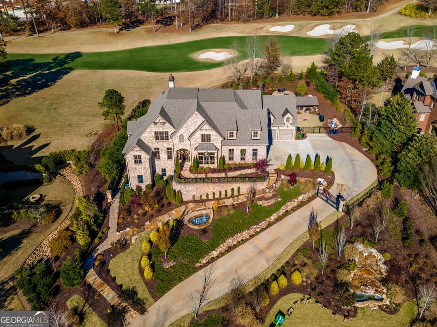 An Unrivaled Showcase of Luxury Living!  Welcome to a true masterpiece of design and craftsmanship-this extraordinary custom estate redefines luxury living, perfectly positioned on the 8th hole of the prestigious Manor Golf & Country Club, a 24-hour guard-gated community offering both exclusivity and serenity.  From the moment you enter, you're greeted with expansive, light-filled living spaces that blend elegance and comfort. The main level centers around a chef's dream kitchen, featuring two oversized islands, top-of-the-line appliances, a walk-in pantry, and an open layout that seamlessly flows into the grand family and living rooms.  Step into the enclosed lanai and take in sweeping golf course views  and the stunning resort-style, heated saltwater pool, complete with a swim-up bar,two stone waterfalls, and a spa-your personal oasis of relaxation and entertainment.  When it's time to host in style, ride the elevator down to the ultimate 5,100 sq ft terrace level, thoughtfully designed for luxurious entertaining. Highlights include:  A 12-seat state-of-the-art theater   A massive 800 sq ft fitness center  Two bathrooms, 12 seater sauna, 6 seater steam room, Jacuzzi  Private guest suite and office, or turn it into a play room.  A spacious billiards/recreation area  A custom-designed pub-style bar  And for the connoisseurs, a cellar crafted with bourbon and whiskey lovers in mind, offering a refined retreat where your collection can be appreciated in style.  The main-level primary suite is a true retreat, showcasing soaring double tray ceilings and breathtaking views of the golf course, all bathed in natural light. It opens directly to the covered lanai, blending indoor comfort with outdoor serenity. The spa-inspired en suite bathroom is pure indulgence-featuring a freestanding soaking tub, an oversized walk-in shower spacious enough for the whole family, dual vanities, dual water closets, and dual custom walk-in closets. And for that extra touch of elegance, there's a beautifully appointed glam vanity-perfect for morning routines or evening prep in your own private sanctuary.  Every detail has been thoughtfully designed to offer both luxury and functionality in one of the most stunning owner's suites you'll find.  Upstairs, you'll find 2 additional master suites,  2 en suite baths in all secondary bedrooms, a massive loft area and office/upstairs family room/office with a picture window overlooking the 8th hole.  Additional features include beautiful hardwood flooring throughout and an additional attic closet-ideal for those who crave even more space.  and an 8-car garage, perfect for your automotive collection. Already approved are plans for a garage expansion with a two-bedroom, two-bath loft and glam barber studio.  This estate isn't just a home-it's a lifestyle, meticulously designed for those who appreciate luxury, privacy, and exceptional living.