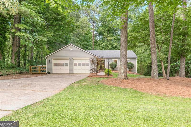 Renovated 4BR/2BA Ranch with Designer Finishes in Prime Woodstock Location with NO HOA! Tucked at the end of a quiet street, this beautifully renovated 4-bedroom, 2-bathroom ranch on a basement offers modern upgrades, custom finishes, and peaceful surroundings just minutes from Downtown Woodstock and top-rated schools. The fully remodeled kitchen features quartz countertops, custom cabinetry, a gas oven, tile backsplash, and under-cabinet lighting. The open layout includes a separate dining room, breakfast area, and a spacious living room with a stunning electric fireplace wall and shiplap accents. LVP flooring runs throughout most of the home, with tile in the bathrooms and carpet in the bedrooms. The primary suite boasts a luxurious six-foot walk-in shower with dual shower heads, heated floors and bidet. A flexible bonus room serves perfectly as an sunroom, office, playroom, or sitting area. The main level also includes a laundry room for added convenience. Upgrades include new windows, a new double front door, new exterior paint, new insulation, a new water heater, and a heated garage-one side converted into a home gym. Outdoor living shines with nearly 1,000 sq ft of deck space, a brand-new lower deck, fenced-in side yard, privacy trees, landscape lighting, and a custom-built bridge over the backyard creek. Located near the upcoming Little River Park on Trickum Rd, you'll soon enjoy trails, aquatic features, playgrounds, and more just moments from home. This move-in-ready home is full of character, comfort, and quality-come see it today!