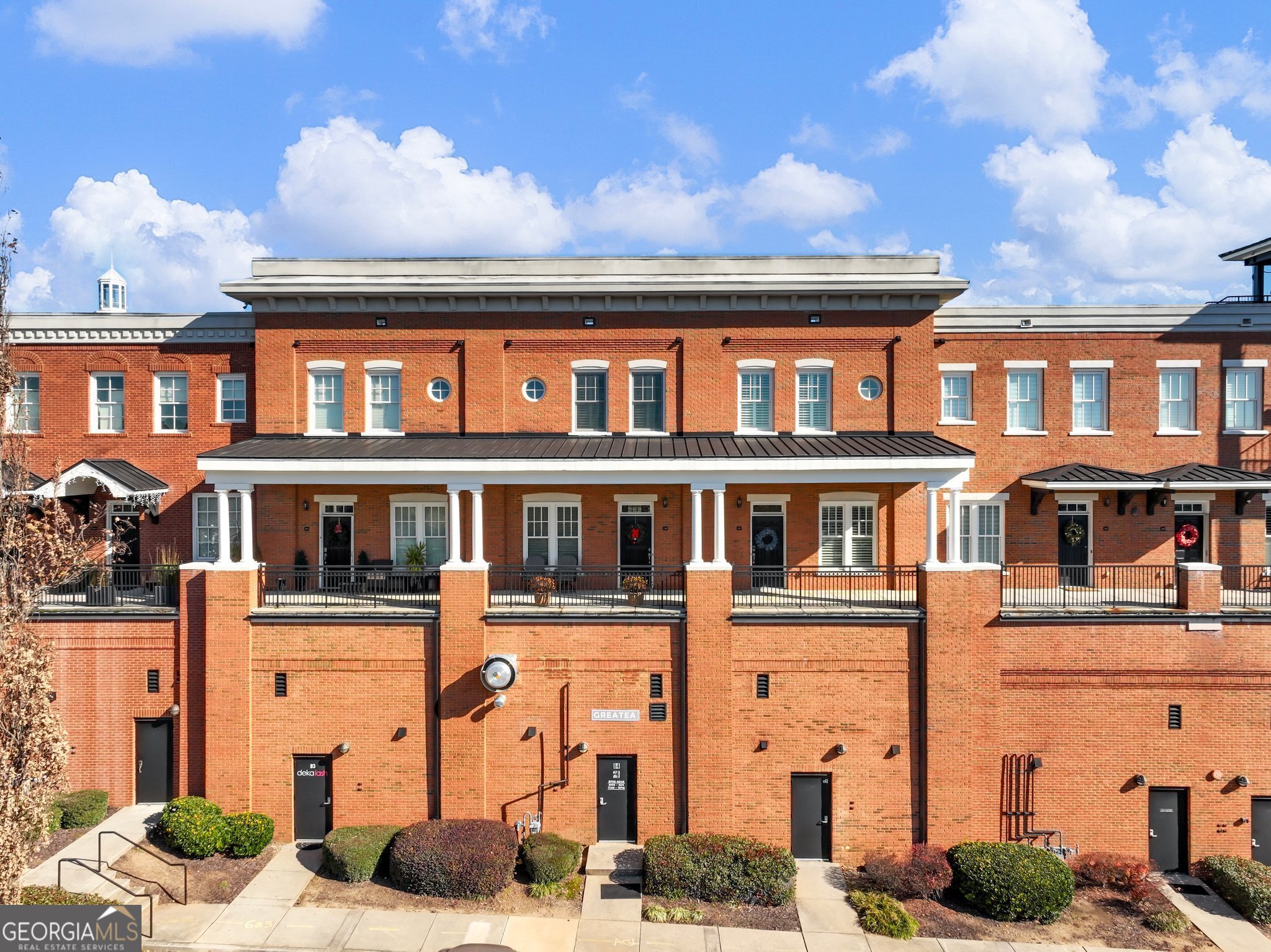Imagine parking your car for the day and walking to dinner, concerts, shopping or just relaxing on your balcony enjoying the morning/night sky over the green. Rarely are these beautiful condos available, as you are afforded the opportunity and convenience of living literally WITHIN Suwanee Town Center Park! Home also has the security of 2 gated garaged parking spaces. You will enjoy a large covered front porch at the home's entrance for when the weather is not cooperating for outside time on the charming balcony! Open the door to almost 2100 sq feet living space and exquisite hardwood floors. To the right you will find a currently utilized Dining Room with Pocket Doors, but this awesome space, complete with plantation shutters, can be utilized to fit YOUR needs...another living space with pull out sofa for extra guests, Office, Playroom.... the possibilities are endless for your living needs! Make your way into a cook's/entertainer's kitchen with counter and cabinet space galore! Plenty of room to add a great furniture island piece in the center! All stainless appliances including trash compactor and 5-burner gas cooktop! The kitchen is open to a Dining Area and Elegant Family Room with Built-in Bookcases and cabinets flanking Fireplace. French Doors with an added transom provide floor to ceiling light! The main level boasts plenty of storage with a huge closet that has also been pre-framed for future elevator to 2nd level. In addition, there is a 2nd large hall closet and half bath. Walk out to one of the larger balconies in the community overlooking the Suwanee City Hall and the serene Lawn, Park and Green space. Unit is right above the Suwanee Art Center and Great Tea! Making your way up the stunning hardwood staircase are the two Ensuites. The Laundry Room is conveniently located upstairs, and the washer/dryer do remain! The Owner's Suite offers double vanities, a large soaking tub, large tiled separate shower and massive closet! The second bedroom is impressive, as well, enjoying a big ensuite with extra large shower and good size walk-in closet! This Home has fresh neutral paint, NEST Thermostats and is a clean palette ready for new owner(s) to make their own! Enjoy a fun new lifestyle in Suwanee Town Center- If you don't know- it is only 2.5 miles from I-85 for easy commuting, but you feel miles away in your own little energetic downtown, which is considered Suwanee's primary gathering place. It is home to 3 inter-connecting walking paths, green space, an interactive fountain, Art displayed around every corner, an outdoor performance stage with 1000 seat amphitheater, and 100,000 square feet of retail and restaurant space! Come make this special place your HOME !