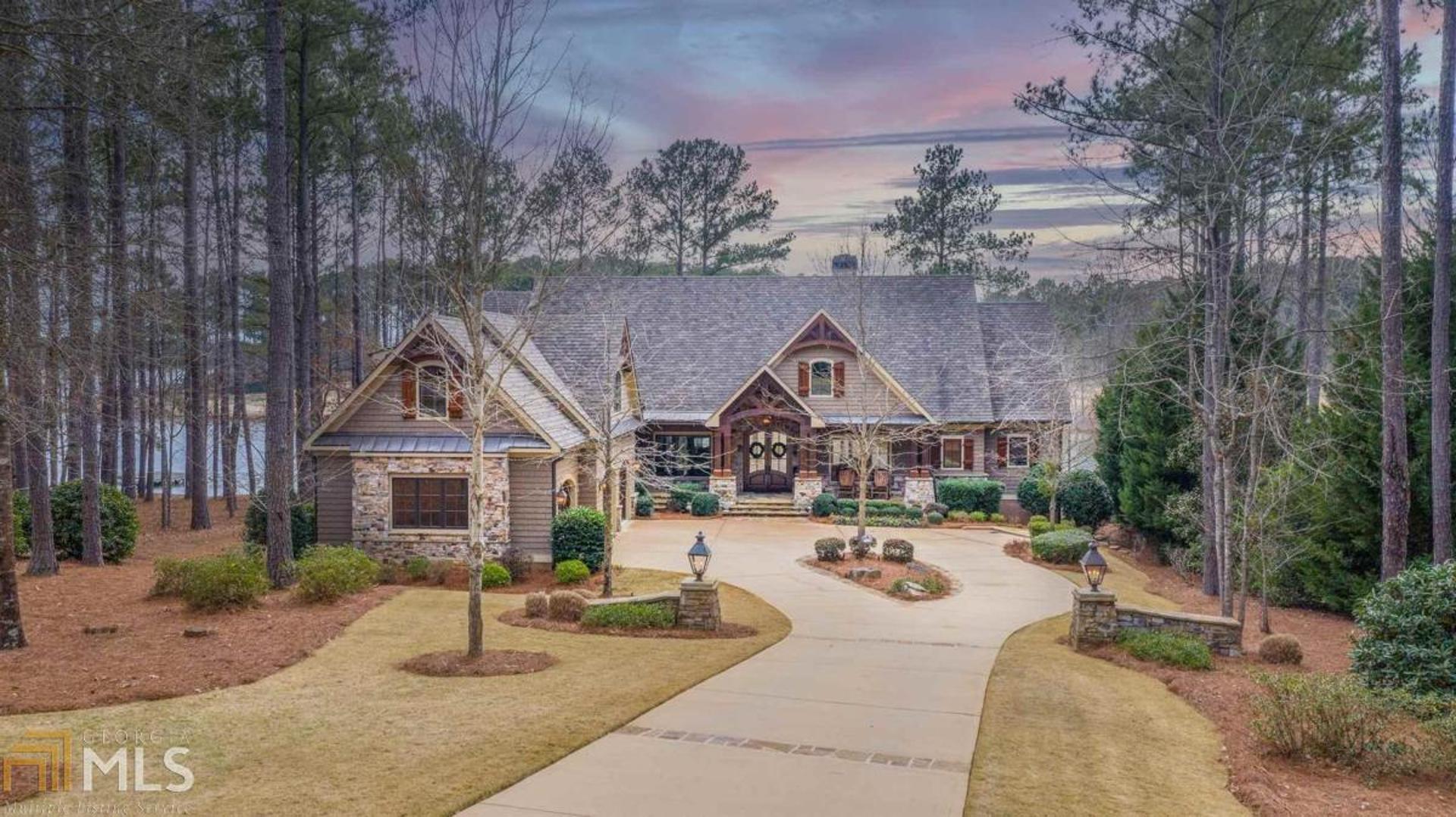 "EXPERIENCE THE BEST OF THE BEST WITH THIS EXTRAORDINARY LUXURY HOME WITH INCREDIBLE VIEWS OF THE LAKE AND THE FAMOUS 18TH HOLE OF THE OCONEE COURSE, LOCATED WITHIN WALKING DISTANCE TO THE LAKE CLUB AND A STONE'S THROW TO THE RITZ CARLTON" This 7,400+ sq ft home by DreamBuilt was created with quality design and craftsmanship, paying close attention to details that are often overlooked in new construction homes. The home blends the gorgeous landscape with over 2,400 sq ft of porches & patios that expand the living space into the outdoors. Inside this stunning home, you will find custom vaulted ceilings, open floorplan, four stone fireplaces, foyer and piano room, office and a library with built-in cabinetry, two covered porches - one with a gas stone firepit overlooking the golf course and lake. The home features a gourmet kitchen with a large walnut top island, pot filler, custom cabinetry with glass displays, Chef-grade appliances, an expansive butlers pantry with sink, shelving, microwave and warming oven. The home also features a China room with a second office with built-in shelving and desk. The mudroom features a pet entrance to the fenced-in pet yard. The spacious garage bonus room offers space for sitting area and bedroom, and could be a perfect bunk room. The Master Suite located on the main level offers gorgeous views of the Lake Oconee sunrise every morning, accented by vaulted ceiling, ensuite bath and a private laundry room. The home elevator takes you to all three levels of the home. Or take the gorgeous curved staircase to the lower level built perfectly for entertaining with spacious family and game room, three bedroom suites with ensuite baths, a full kitchen with bar that opens to the outdoor area that includes a four season expansive stone patio, pool and hot tub and a fireplace. There is a "cabana" bathroom accessible from the pool patio. Walk to your dock and watch the golfers across the lake or the fireworks display at the Ritz during summer. The flat lake backyard is a rare find "inside the gates." There is ample storage space, irrigation from the lake, 3-car garage, 4-HVAC systems, Sonos system, built-in gas grill and smoker. This is your own "staycation" resort with the best location at Reynolds Lake Oconee. Membership is available.