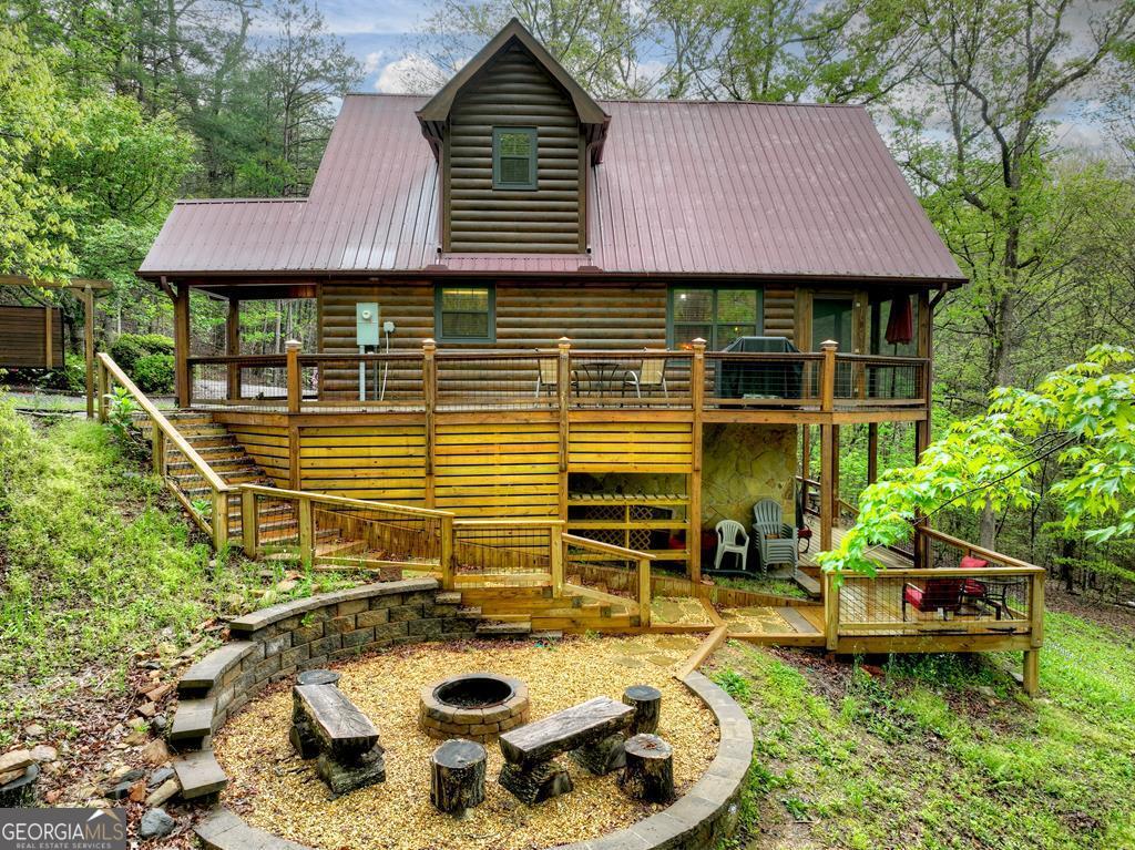 Escape to your perfect mountain retreat with this beautifully renovated cabin nestled in the tranquil woods just minutes from Blue Ridge, Georgia. This home seamlessly blends modern comforts with rustic charm, offering a warm and welcoming atmosphere surrounded by nature. Step inside to find a spacious living area with a cozy fireplace - perfect for curling up with a good book, movie night, or playing games with loved ones. The fully updated kitchen features brand-new granite countertops, a stylish new sink, and all modern appliances, making it easy to cook up your favorite meals. Outside, unwind on the classic porch swing, roast marshmallows around the stone firepit, or take a relaxing dip in the private hot tub under the stars. With nearby rivers ideal for fishing, this is a nature lover's paradise. Whether you're looking for a weekend getaway, vacation rental, or full-time escape, this mountain cabin offers the perfect blend of comfort, character, and location.