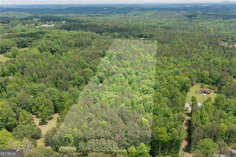 Nestled in the tranquil countryside of Dallas, Georgia, this exceptional 9.96-acre parcel on Benson Road offers a rare opportunity to create your ideal living space or investment venture. With approximately 276 feet of road frontage, the rectangular lot boasts gently rolling topography, providing multiple potential building sites to suit your vision. The property is predominantly wooded, offering a serene and private setting, enhanced by a small, meandering creek that adds to its natural charm. Across the street, enjoy picturesque views of a neighboring horse farm, contributing to the idyllic rural ambiance. Whether you're dreaming of constructing a single-family residence, developing multiple homesites, or establishing a family compound, this versatile land accommodates a variety of possibilities. Its peaceful surroundings and scenic vistas make it an ideal canvas for your aspirations. Located in a desirable area of Paulding County, this property combines the tranquility of country living with convenient access to local amenities. Don't miss the chance to own a piece of Georgia's beautiful landscape and bring your dreams to life on this remarkable acreage. Note: Property boundary lines shown in photos are approximate and provided for reference only. *New survey just completed May 2025*