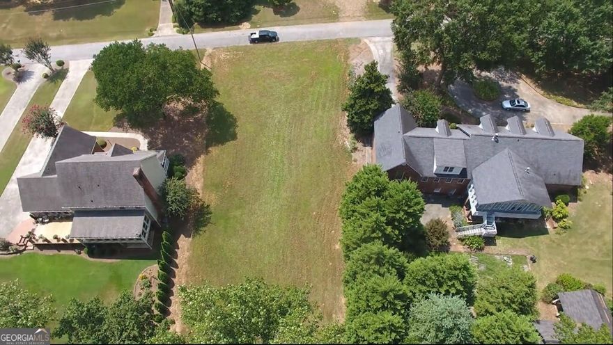 Prime building lot in Sunset Hills Country Club in Carrollton, GA. Cleared of trees for construction, offering a most convenient location in the city limits. The lot spans 100 feet wide (90 feet at its narrowest) by 206 feet deep. Site plan + Custom house plans for a 5,400 sf home are available that were drawn for this lot. A new survey, city water, and  City sewer connection have been established, ensuring a smooth development process. Resident members will enjoy access to upscale amenities such as golf, tennis, swimming, and fine dining.