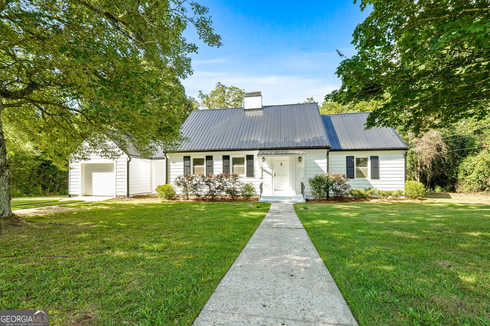 Welcome to 306 Spencer St! Full of charm and character, this beautifully renovated 1945 home offers the perfect blend of original details and modern upgrades. Located on one acre just off the Gordon State College campus in downtown Barnesville, this 3-bedroom, 2-bath home also includes a large bonus room and a dedicated office-giving you plenty of flexible living space. The kitchen showcases original cabinets full of personality, now paired with sleek quartz countertops, stainless steel appliances, and a wine cooler for a touch of luxury. The main-level bathroom has been completely updated with spa-like finishes, creating a relaxing retreat. Just off the living room, you'll find an expansive sunroom filled with natural light, perfect for lounging or entertaining. A breezeway leads to the laundry room and attached garage, adding convenience and charm. With its blend of historic character and stylish upgrades, this home is truly one of a kind.