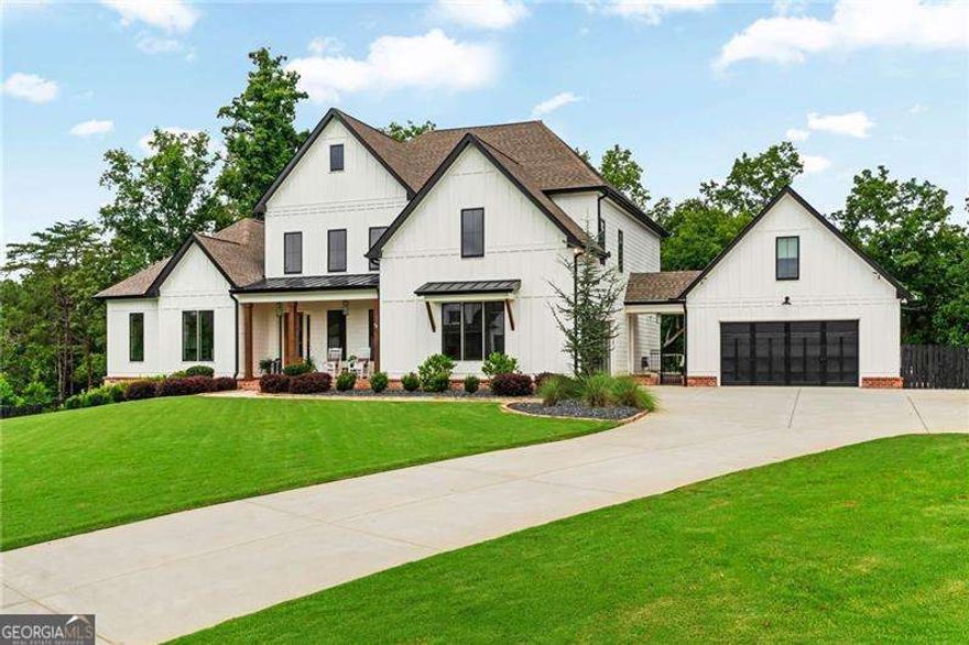 Once-in-a-Lifetime Luxury Estate with Resort-Style Backyard on 2.5 Acres - UNLIKE ANYTHING ELSE ON THE MARKET!  This extraordinary estate offers a rare opportunity to own a property that blends the ultimate in luxury living with resort-style amenities. Situated on 2.5+/- acres of lush landscaped grounds in a prime school district, this home is designed for entertaining, relaxation, and everyday comfort at the highest level. Inside, you'll find gorgeous modern finishes with cedar beams throughout the main level, an open floor plan with a large family room that includes built-ins, cozy stone fireplace and sliding doors opening the indoors to the outdoors.  A massive gourmet kitchen featuring an oversized island with seating for up to 10, quartz countertops, double ovens, oversized refrigerator, and a vented range with hood. A vaulted keeping room/ breakfast area with shiplap and custom lighting adds to the charm of this spectacular home!  This luxury kitchen also offers a custom walk-in pantry with a grocery door makes everyday living effortless. The main-level primary suite is a private retreat with soaring ceilings and a spa-like bath including a soaking tub, oversized shower, and double vanity. Owner suite closet includes custom built-ins, island with drawers, makeup vanity/desk and FULL laundry with sink! Upstairs, four spacious secondary bedrooms each offer their own private en suite bath and walk-in closets. A second fantastic laundry upstairs with cabinets and sink. The finished terrace level includes a sixth bedroom, full bath, a state-of-the-art media room with seating for 10 and an incredible sound system, a fitness room, and a rec room. Terrace level also offers a third laundry making laundry a breeze on any floor! A whole-home speaker system carries throughout the interior and exterior, creating the perfect setting for entertainment.  The backyard is a true PARADISE with diving ledges, resort-style slides, waterfalls, grottoes, tanning ledges, and a massive hot tub, along with pickleball and basketball courts, a putting green, and an in-ground trampoline. Outdoor living continues with a full kitchen, outdoor bathroom, sauna, private outdoor shower and spectacular outdoor fireplace tucked in the trees for majestic evenings!  Covered and screened deck with fireplace is the perfect spot for morning coffee! Custom lighting enhances both the home and backyard, creating a stunning evening ambiance, while a full irrigation system keeps the grounds lush and a full house generator provides peace of mind. A rocking chair front porch adds classic Southern charm, while the attached two-car garage and detached two-car garage provide space for four vehicles in total. Above the detached garage, a private office / bonus space is ideal for a home office, studio, or man cave. The property also features a private hiking trail that leads directly to Canton Creek and waterfall.  This one-of-a-kind estate combines breathtaking design, unmatched amenities, and an outdoor resort experience unlike anything else on the market.