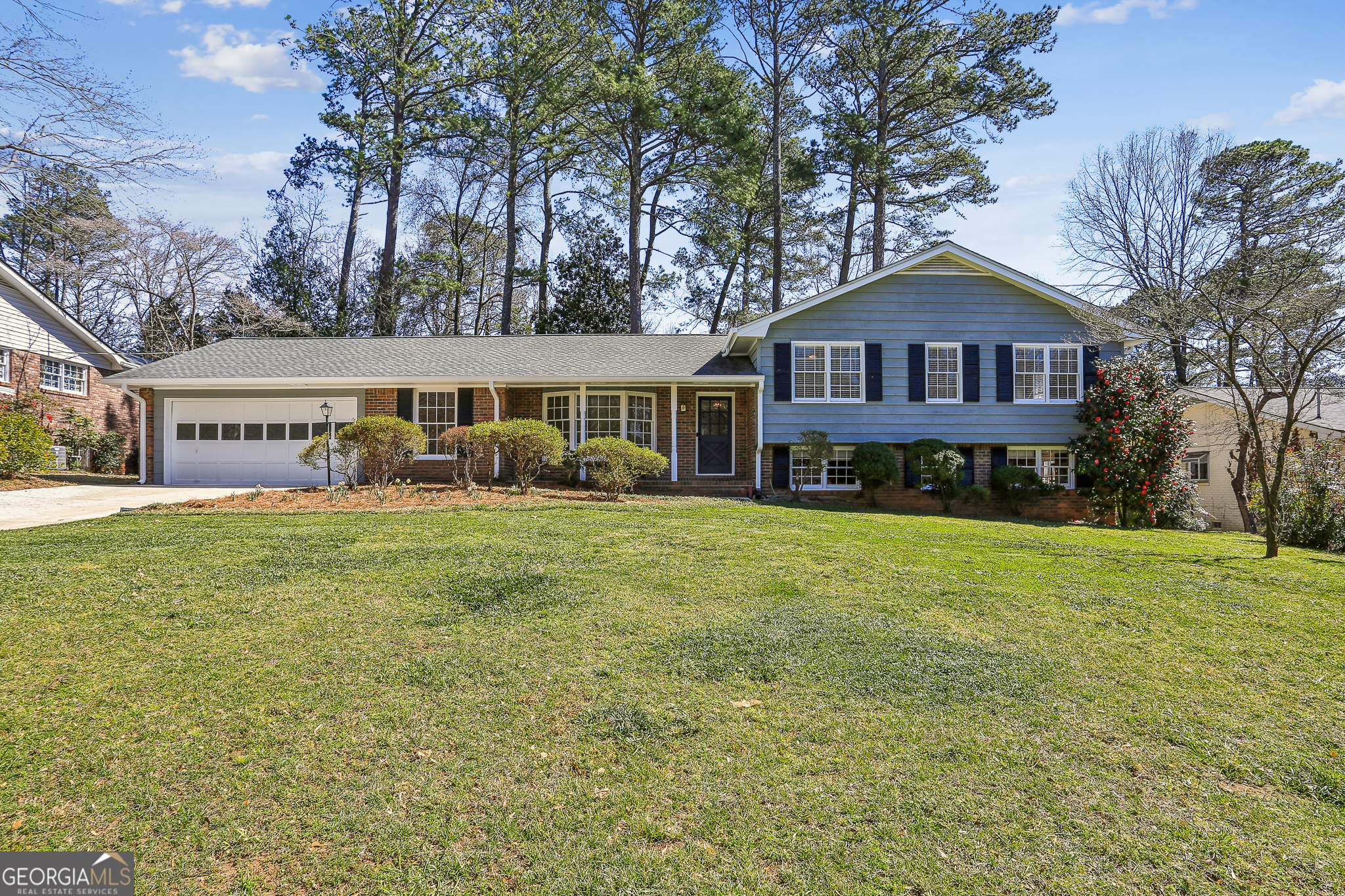 A spacious and sunny split-level home awaits you in the charming Stratford/Grove Meade/Hyde Park neighborhood of East Cobb. The well-manicured lawn, with a bed full of flowering plants, invites guests to the front door and a small entrance foyer. The front living room, with bay windows, was used by the previous owners as a home office. The large kitchen features granite countertops, custom cabinets, a work island with a hanging pot rack, and a breakfast bar. The open kitchen/family room provides endless opportunities for entertaining, family time, and cozy get-togethers in front of the fireplace. This home has been freshly painted inside and out, and new carpet and luxury vinyl flooring were added. Up a small stairway are three bedrooms, two full bathrooms, and a vanity area. The primary bedroom, with original hardwood flooring and an ensuite bathroom, overlooks the backyard and is quite large by neighborhood standards. The two bedrooms in the front are connected by a full bathroom. Heading downstairs from the family room is a sunny walk-out basement; the finished half makes for a great office, man-cave, teen hangout, or an extra family room. The unfinished half offers expansive storage options and is stubbed for future conversion into two additional rooms and a full bath - perfect for an in-law suite. A new driveway leads to the two-car garage that contains custom-built shelving and access to the kitchen and backyard. A hidden fence and evergreen foliage enclose the private backyard and patio - great for kids and dogs to play safely and for hosting parties and family cookouts. A sunny pocket garden offers the opportunity to grow fresh flowers and vegetables. The backyard is traversed by an irrigation system that can assist gardeners with their activities. The neighborhood offers an active voluntary HOA which organizes frequent activities for the residents; one block from the house is the Meadowgrove Swim and Tennis Club with a vibrant membership, quality tennis courts, and a swimming pool open from mid-May through Labor Day. This wonderful, quiet community is conveniently located near I-75/285, The Battery/Truist Park, and numerous shopping, dining, entertainment, faith, and recreational options.