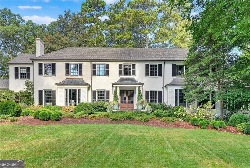 Perfectly located in the heart of Historic Tuxedo Park, this beautifully renovated residence combines timeless elegance with modern sophistication. Designed for entertaining, the main level features multiple living spaces, a banquet-sized dining room, and a stylish pub/lounge for intimate gatherings. The chef's kitchen impresses with an oversized L-shaped island, a caterer's area, and a breakfast room with custom banquette seating. A screened porch with a wood-burning fireplace extends the living space outdoors, opening to a resort-style backyard with a sparkling pool, expansive bluestone patio, and level landscaped lawn. The luxurious primary suite offers dual walk-in closets and a spa-like marble bath, while three additional en-suite bedrooms and an upstairs den provide comfort and flexibility. A newly built entertainment pavilion sets this property apart, boasting vaulted wood-beam ceilings, a golf simulator, full bar, and bath-an unrivaled leisure retreat. A charming guest cottage with two bedrooms, full bath, kitchen, and living room ensures privacy and comfort for guests. Additional highlights include a whole-house generator, iron doors, wood-beamed ceilings, and gleaming hardwood floors throughout. A rare blend of classic craftsmanship and modern amenities, this Tuxedo Park treasure is move-in ready.