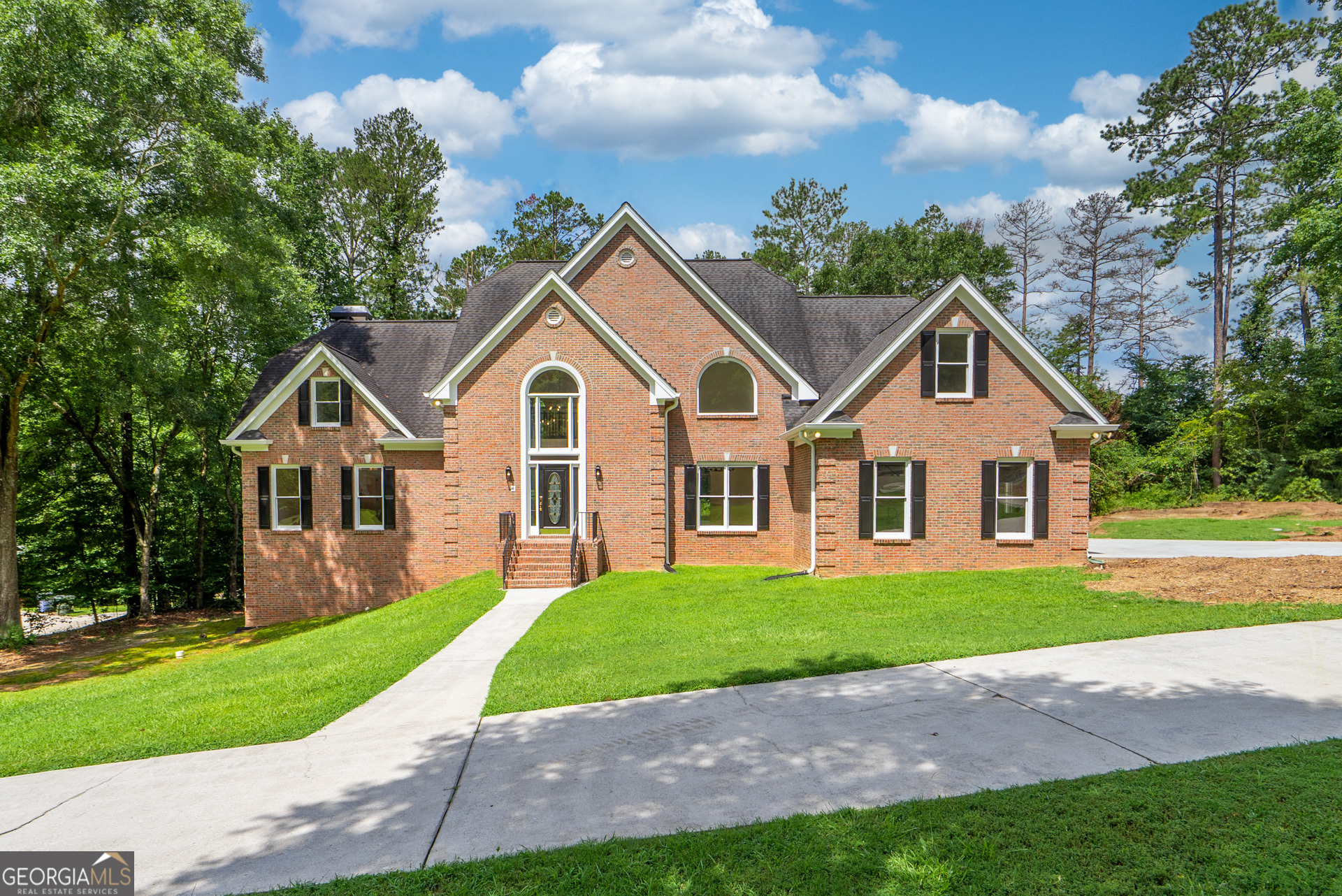 Welcome to this beautifully updated brick home nestled on 2.39 acres in charming Oxford, Georgia. Step through the dramatic two-story foyer and be greeted by an open, airy floor plan that exudes timeless elegance and modern flair. New LVP flooring flows throughout the main level, creating a sleek and cohesive feel. Entertain with ease with the formal dining room-perfect for hosting holiday gatherings and dinner parties. The space flows seamlessly into the soaring two-story great room, featuring a fireplace and access to the rear deck, ideal for indoor/outdoor living and entertaining.The chef's kitchen is a dream come true, complete with quartz countertops, shaker-style cabinetry, brand-new stainless steel appliances, and abundant prep and storage space and a breakfast area. Just off the kitchen, is a cozy family room with a fireplace. A stylish main-level powder room features updated fixtures, cabinetry, and quartz finishes and also located on the main is a spacious laundry room that has new cabinets with quartz and a utility sink.The main-level owner's suite is a serene retreat with its own fireplace, a spa-inspired ensuite bath featuring a freestanding soaking tub, marble tile flooring, a luxurious walk-in shower, and double vanities with quartz countertops. Upstairs, a catwalk-style hallway overlooks the great room below, creating striking architectural views. One of the upstairs bedrooms features its own private en-suite bath, while two additional bedrooms share a connected full bath with dual quartz vanities and stylish finishes. A spacious bonus/flex room-complete with a charming oval window-offers the perfect space for a playroom, office, or media room.The full daylight basement is unfinished and stubbed for a bathroom, providing ample potential for future expansion. With fresh interior and exterior paint and new carpet upstairs, this home is truly move-in ready. Don't miss your chance to own this exceptional home that blends luxury, comfort, and convenience-all just minutes from Covington and Conyers, schools, shopping and more.
