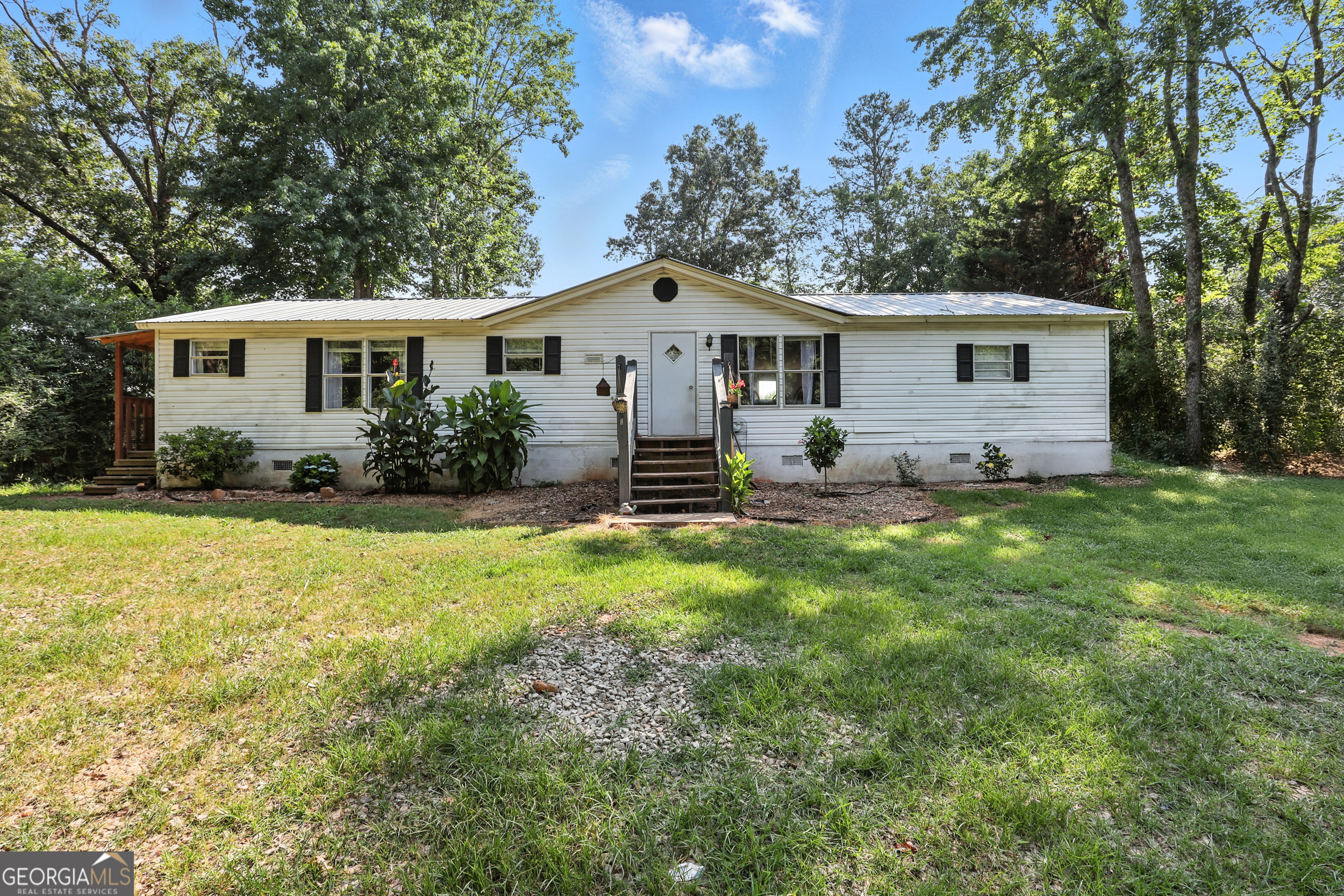 Welcome to your new home! This beautiful three-bedroom, two-bathroom manufactured home is perfect for anyone looking for a comfortable and updated living space. As you step inside, you'll notice the large and spacious living room that opens up to the kitchen. The bedrooms are cozy and comfortable, providing plenty of space for rest and relaxation. The two bathrooms are updated and spacious. The yard is great for outdoor activities, with plenty of room for gardening, playing, or just enjoying the beautiful views of the peach tree farm behind the home. In addition to the great yard, the home also comes with an outdoor building, providing plenty of space for all your storage needs. Newer roof, water heater, and HVAC. Don't miss this one!