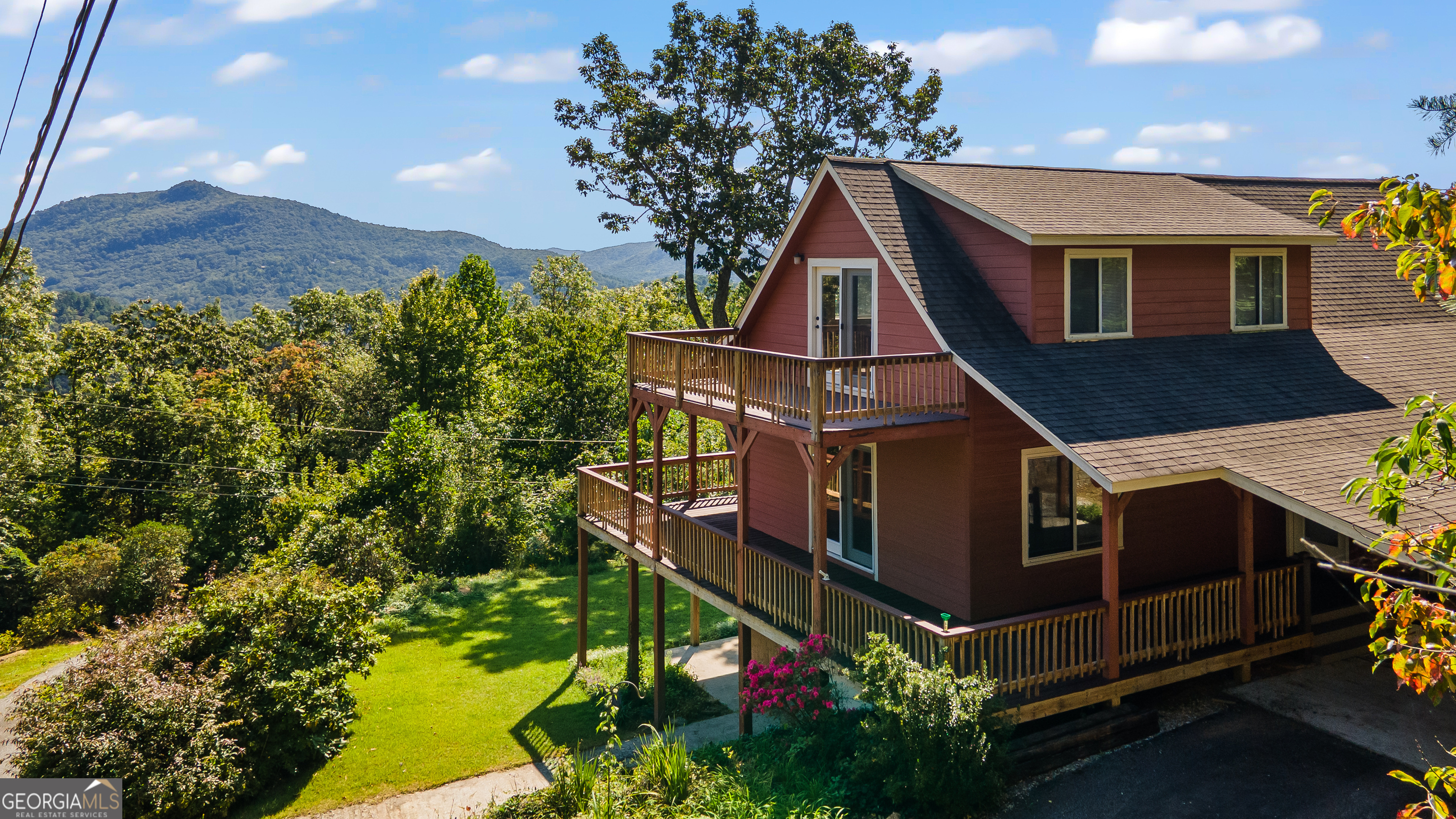 Incredible views just five minutes from the heart of town! Welcome to this beautiful mountain retreat located just above downtown Clayton, Georgia, where the only thing that exceeds the views is your proximity to town. This home features 3 bedrooms and 3 baths, one on each level for ultimate privacy and flexibility. Both the main floor and upper-level feature large decks to take in the outstanding 180-degree views. The partially covered main floor deck is perfect for grilling and dining. The living room soaks in light from the large adjacent sunroom and maximizes your eastern sunrise view. Vaulted ceilings on the main floor with white-washed wood enhance the sense of space while adding a warm, inviting touch. The living area boasts a striking stone gas log fireplace, perfect for cozy evenings, while the open kitchen offers modern appliances and a full breakfast bar. Rounding out the main floor is a small office off the living room, a large bedroom, full bath, laundry closet and pantry. The upper level has a large bedroom, full bath with double vanity and a loft space overlooking the main floor. The terrace level features the third bedroom and bath, a walkout patio with direct access to a small flat yard, a second living room and a one car garage w/ adjacent workshop. Downtown Clayton is a welcoming community focused on outdoor living. The burgeoning town is home to an excellent local dining and shopping scene that may be North Georgia's best kept secret. The surrounding area is rich with hiking trails, waterfalls, and cultural attractions. Black Rock Mountain State Park, the highest state park in Georgia, can be seen from the deck. This home benefits from paved road access right to the front door and is being sold fully furnished.