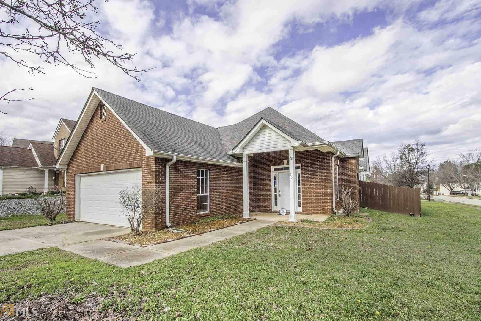This Locust Grove corner lot home offers a two-car garage, gas heating, a kitchen pantry, a fireplace, vaulted ceilings, a walk-in master closet and a master bathroom with dual sinks and a separate shower and tub.