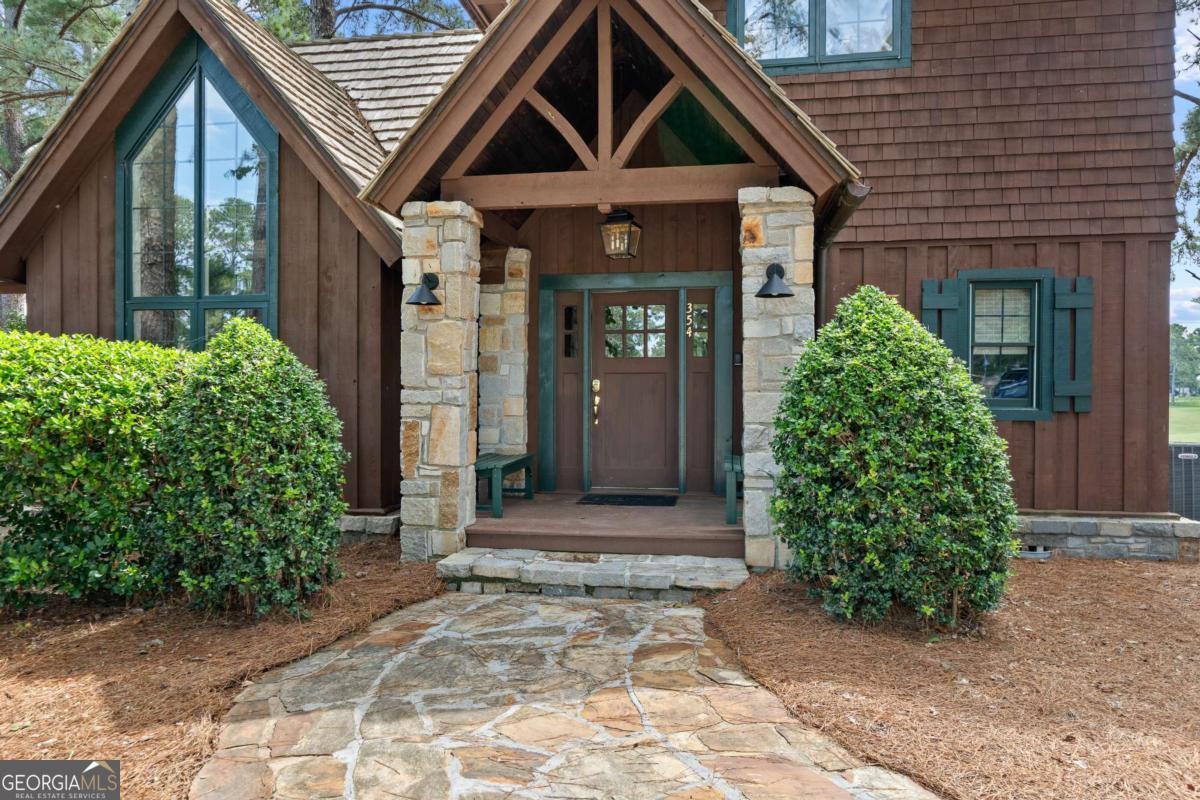 Dubbed "The Cottage on the Course," this turnkey bungalow is ready for you to move right in! You'll feel like you're on vacation each time you drive through the gates of the prestigious Cuscowilla Golf & Country Club at Lake Oconee. Park your car, walk in, drop your bags and get right out onto the award-winning golf course, tennis and pickleball courts or board your boat at the nearby dock for a day on the lake. As a private, members-only community, Cuscowilla offers unmatched amenities including 24/7 guard-gated entry, a phenomenal restaurant & bar, beautiful pool with private beach and cabana bar, multiple tennis and pickleball courts, a large gym, a community garden, a dog park, a playground and basketball court, a chapel, multiple stocked ponds and a variety of exciting social activities throughout the year. This particular home sits in an ideal location overlooking the 9th green. Enjoy breathtaking sunrises and watch golfers round the turn from the comfort of your covered rear porch. You'll love the fully-renovated interior that's being sold fully furnished (down to the dishes!) so you can start enjoying your "home away from home" immediately! With designer touches throughout, this cottage feels like it's right out of a magazine. The painted interior, soaring beamed ceilings, high-end lighting, gorgeous heart pine hardwood floors, a two-story flagstone fireplace, fully remodeled kitchen and bathrooms and large bedrooms means this home is both chic and cozy. Easily sleep up to 8 comfortably! New plumbing, new hot water heater, new driveway and a water softening system are just a few of the 'behind the scenes' items that make this a low maintenance home. Walk right out to all of the neighborhood amenities just steps from the front door. This home is the perfect "lock and leave" getaway for which you've been looking - the ideal way to get into the Cuscowilla community for hundreds of thousands less than other properties! A $25,000 credit toward a golf membership is available with the sale of this home!