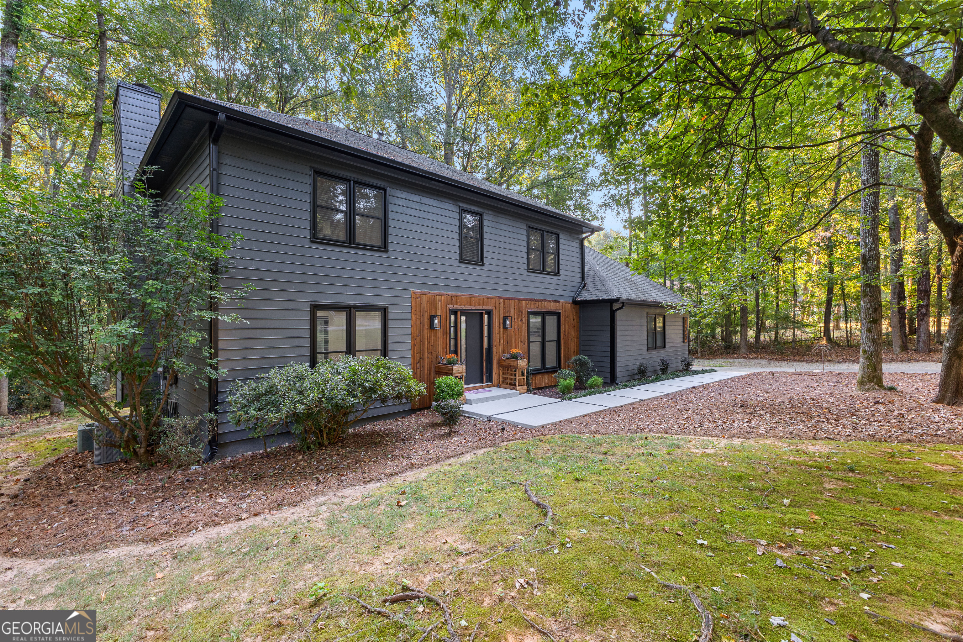 Welcome to 125 Marilyn Court, a beautifully reimagined residence on 3 private acres in the heart of Fayetteville, GA. Just minutes from Trilith Studios, the U.S. Soccer National Training Center, Piedmont Fayette Hospital, and Hartsfield-Jackson Atlanta International Airport, this home offers the perfect blend of convenience, community, and comfort. This two-story, 2,210 sq. ft. home features 4 bedrooms and 2.5 bathrooms and has been nearly completely renovated with modern updates throughout. The exterior includes freshly repainted cedar siding, new gutters with leaf guards, and brand-new windows. Inside, you'll find luxury vinyl flooring, a stunning new fireplace wrapped in cedar and tile, and thoughtfully designed spaces. The kitchen features brand-new soft-close shaker cabinets, quartz countertops, and new appliances including a gas stove with air fry capabilities. A breakfast nook overlooks the backyard, and the large laundry room adds convenience. The primary suite offers a spacious layout with a walk-in closet and spa-inspired bathroom with a soaker tub, LED vanity, and walk-in glass shower. The guest bathroom is also fully updated, serving the three additional bedrooms. Outdoor highlights include a new deck, concrete walkway, professional landscaping, and outdoor lighting. Additional upgrades include a new AC system for the downstairs, updated light fixtures and fans, and a full suite of smart features: AT&T fiber internet at 1.2 Gbps, Wi-Fi controlled exterior lights, smart thermostat, keypad door lock, Ring camera, USB outlets, a 50-amp EV charging port, and a MyQ Wi-Fi garage opener. Backing up to Ginger Cake Creek, this property offers privacy, modern amenities, and an excellent location.