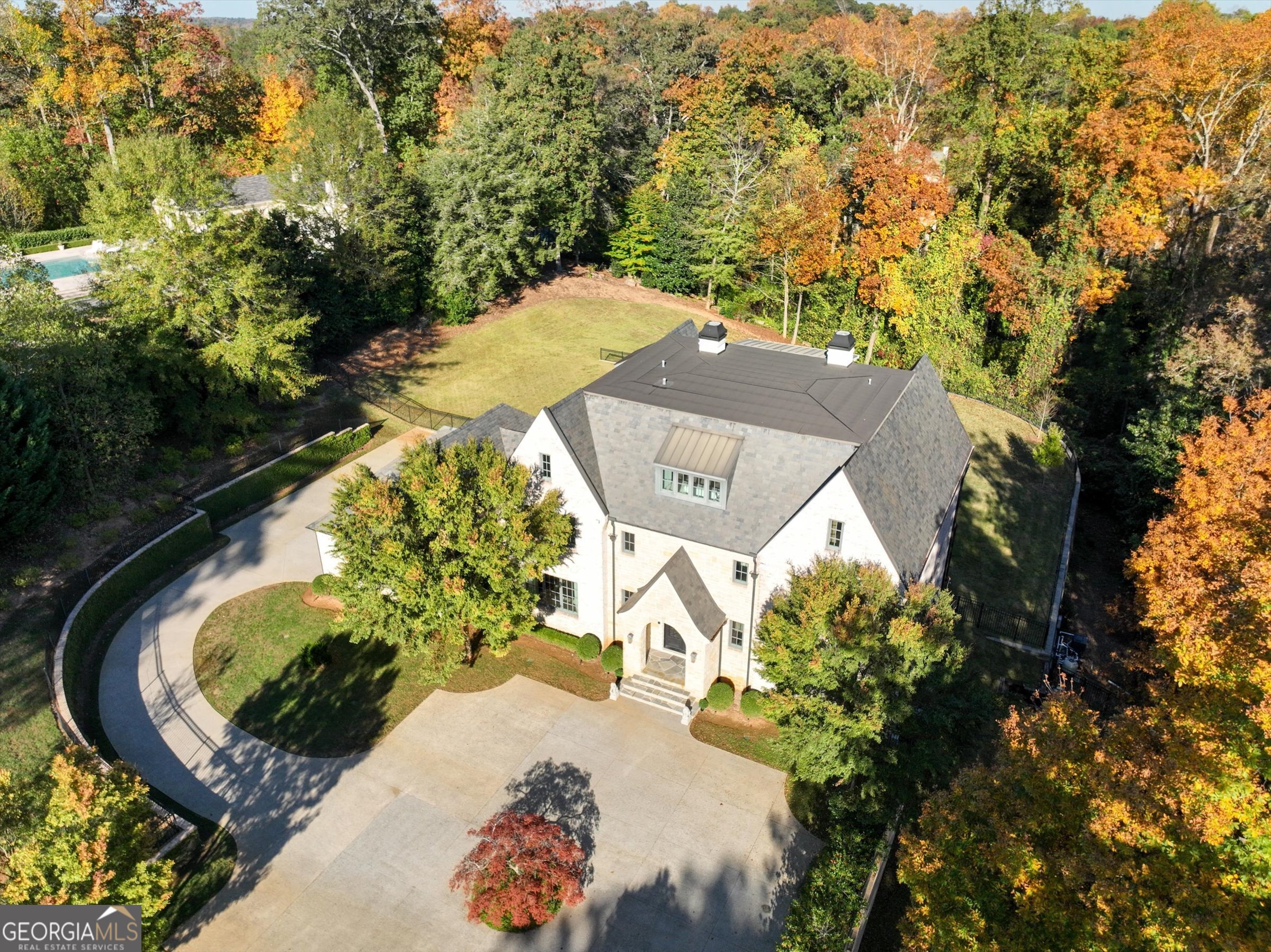 Spetacular masterpiece on one of the most beautiful 2.46 acre level lot settings in Buckhead has been thoughtfully constructed in 2018. Gated access as home can't be seen from street providing ultimate privacy in the prestigious Tuxedo Park. A stunning extended drive from the gate leads to a circular driveway. The home includes an elevator that reaches all levels. The 3rd top level floor features only the private owner's suite with a sitting area, wet bar, fire place, oversized walk-in closets, luxurious bath with dual vanities, walk-in shower, soaking tube and a private covered deck overlooking the stunning saline gunite heated pool and backyard. 2nd floor features 3 spacious bedrooms all with en-suite baths and laundry room. Terrace level includes a gorgeous kitchen, a culinary masterpiece that showcases high-end appliances opens to the family room with windows framing the view of the pool and the opulence private backyard. Also on the main floor is an additional spacious bedroom with en-suite bathroom, overlooking the pool. The luxurious basement amenities include a media/theatre room, two recreation rooms with built-in bar, a walk in pantry and additional spacious bedroom ensuite with bathroom. Ample parking is provided, with a 4-car garage. This property embodies design, luxury and functionality, offering a truly exceptional lifestyle. Tax records do not reflect the accurate year built, number of rooms and square footage.