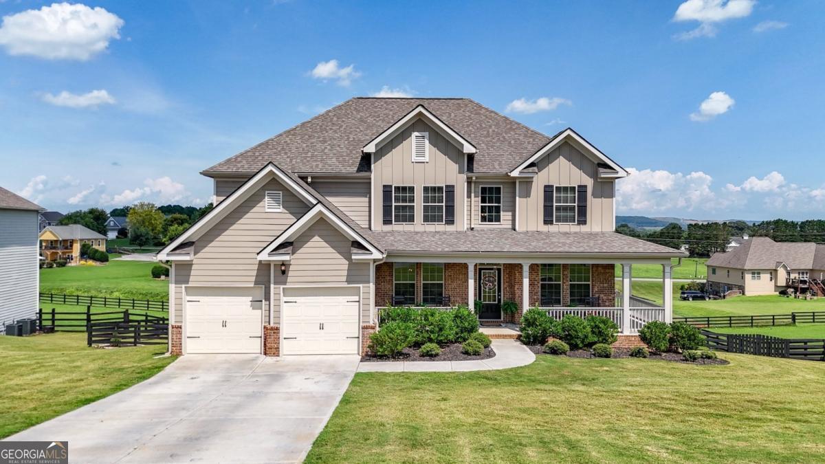 Built in 2023 and meticulously maintained, this like-new residence offers timeless design, refined finishes, and a harmonious blend of elegance and everyday comfort in a scenic mountain view setting. A grand two-story foyer welcomes you inside, setting the tone for the spacious and thoughtfully designed interior. To the left, a formal dining room with coffered ceilings offers an elegant space for hosting. To the right, a flexible living area adds both style and function, perfect as a home office, sitting room, or play space. At the heart of the home, the open-concept family room features a beautiful fireplace and flows seamlessly into the casual dining area and gourmet kitchen. Designed for both everyday living and entertaining, the kitchen showcases granite countertops, stainless steel appliances, a breakfast bar, and ample cabinetry and prep space. A full guest suite is located on the main level, with a well-appointed bathroom that offers dual access, from both the bedroom and the main living area, creating a versatile and private retreat for overnight guests. Upstairs, the expansive primary suite feels like its own private wing, complete with a separate sitting area, tray ceilings, and two oversized walk-in closets. The en suite bath evokes a spa-like retreat with dual vanities, a deep soaking tub, and a separate glass-enclosed shower. Secondary bedrooms are generous in size, with one enjoying a private bath and two sharing a well-appointed hall bath. A conveniently located upstairs laundry room adds everyday ease. The home offers ample storage throughout, including walk-in closets, extra linen closets, and an unfinished daylight basement that provides room to grow, already stubbed for a bathroom and ready for your custom finish. Outdoor living is just as inviting, with a spacious front porch, an elevated back deck ideal for morning coffee or sunset views, and a covered patio that extends from the walk-out basement. A fenced backyard features stone steps, lush landscaping, and a firepit area for cozy evenings under the stars. Located near neighborhood amenities and just minutes from conveniences, this property offers the perfect blend of luxury, comfort, and thoughtful design, ready to welcome you home.