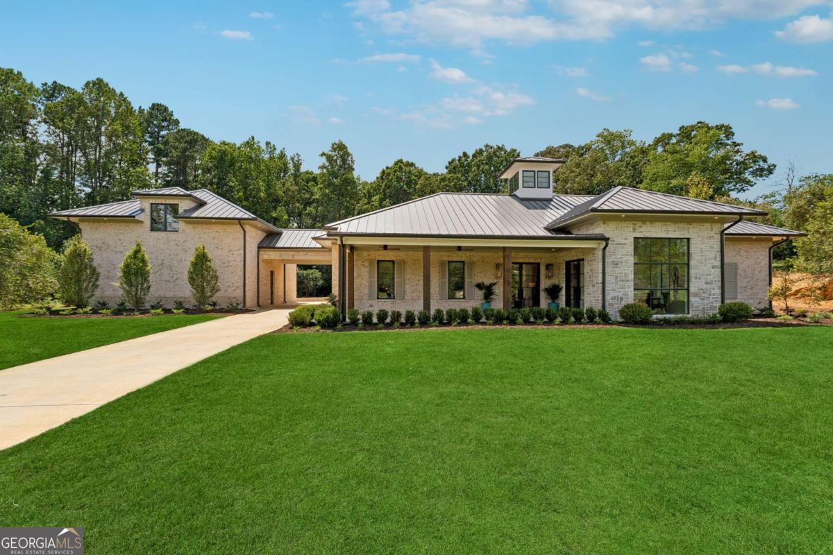 Prepare to be blown away with this exquisite new construction luxury ranch MODEL home in Shiloh Preserve, Forsyth's newest gated luxury custom home community. This home is the perfect floorplan for the Empty Nester, featuring a complete primary suite wing on the main level with oversized his-and-hers walk-in custom closets, a dry sauna, steam shower, dual his-and-hers water closets, an inviting freestanding master bathtub, and the most elegant finishes you have ever seen. The beautiful oversized kitchen boasts high-end appliances, including a Sub Zero refrigerator and Sub Zero freezer, along with a walk-in scullery for amazing storage space and high-end cabinetry throughout. Enjoy the convenient pot filler and glorious natural light that fills the room each morning. The luxurious chef's kitchen continues to impress, complete with Quartz countertops, an oversized center island with seating, and a view of the stunning living room that's ideal for entertaining. The bright and airy great room features a custom stone fireplace, a skylight to maximize natural light, rope lighting accentuating the ceiling line, an elegant bar space, and an extraordinary wall of folding doors that will open the space dramatically to enjoy the outdoor living kitchen. The office on the main is well appointed with magnificent window selections and beautiful lighting fixtures and a secondary entrance. The Carriage House provides privacy for your guests, offering a full guest suite with a kitchenette that overlooks a stunning lot, perfect for your custom in-ground swimming pool. Relax with a nice glass of wine or a fresh lemonade on the private back porch while enjoying the outdoor fireplace in the fall, or fire up the built-in custom grill for a summer barbecue. Set on a 1.19-acre lot that is level and private, the possibilities are endless for adding a pool house, additional garage space, or expanding the home to meet your custom needs. Shiloh Preserve is a serene subdivision with tree-lined streets, gas-lit lanterns, beautiful level lots, and a gated entry for security and privacy. Each lot offers rear privacy and features mature Crepe Myrtles throughout. This eco-friendly community showcases stunning custom builds by Southern Gentry Homes, an elite Atlanta-based homebuilder. Conveniently located for interstate access, shopping, and entertainment, it's perfect for those seeking an upscale luxury downsize with the finest quality architectural design and craftsmanship. *Pricing and features are subject to change. Pool price is not included as it will be custom designed by the buyer.*