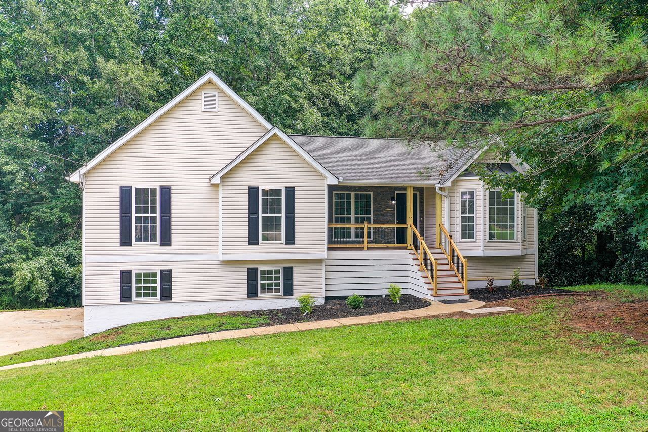 This fully renovated 3-bed, 2-bath home blends modern finishes with comfort and flexibility. Enjoy brand-new LVP flooring throughout, updated lighting, ceiling fans, and a cozy fireplace in the living room. The kitchen features white cabinets, granite countertops, sleek black appliances, matte black faucets, and black cabinet handles for a stylish, cohesive look. Both bathrooms showcase white quartz countertops, gray ceramic tile, and a beautifully tiled walk-in shower in the primary suite, complete with a large walk-in closet. Matte black faucets continue the modern design throughout. Laundry hookups are available both upstairs near the kitchen and in the unfinished basement. The brand-new front deck and renovated back deck offer outdoor charm, while the freshly renovated 2-car garage includes brand-new doors and remote openers. The basement is framed with laundry connections and ready to be finished into a bedroom, office, or in-law suite-customize it to your needs! Located just 10 minutes from High Shoals Falls and 45 minutes from Downtown Atlanta, this move-in-ready home offers style, space, and potential in a peaceful neighborhood.
