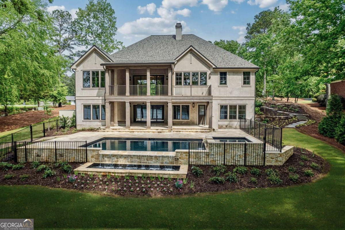 Experience the allure of a FULLY REMODELED home, transformed both inside and out! Welcome to your dream home, where timeless European elegance seamlessly blends with modern luxury in this exquisite renovation on Lake Oconee. This exceptional property boasts four generous bedrooms, four beautifully appointed full bathrooms, and two additional half bathrooms, ensuring abundant space for families and guests alike. Don't miss your chance to claim this stunning masterpiece! Step into the elegant European-style kitchen with a custom white oak island at its heart, complemented by custom cabinets and a sophisticated stone backsplash. An inspiring scullery awaits, perfect for culinary endeavors. Two generously sized bedrooms, including a luxurious primary suite with a custom closet and dressing table, are conveniently located on the main level. The home offers versatile spaces that can be transformed into an office or gym, ensuring endless possibilities for your lifestyle. Additional features include a three-car garage, a whole-house water softener, and integrated speakers throughout the home. The beautifully landscaped exterior, complete with designer lighting, creates an inviting atmosphere. The outdoor area features Italian pavers surrounding a pool and spa, offering breathtaking views of Lake Oconee. This property combines luxury, comfort, and a prime location, making it a true gem.