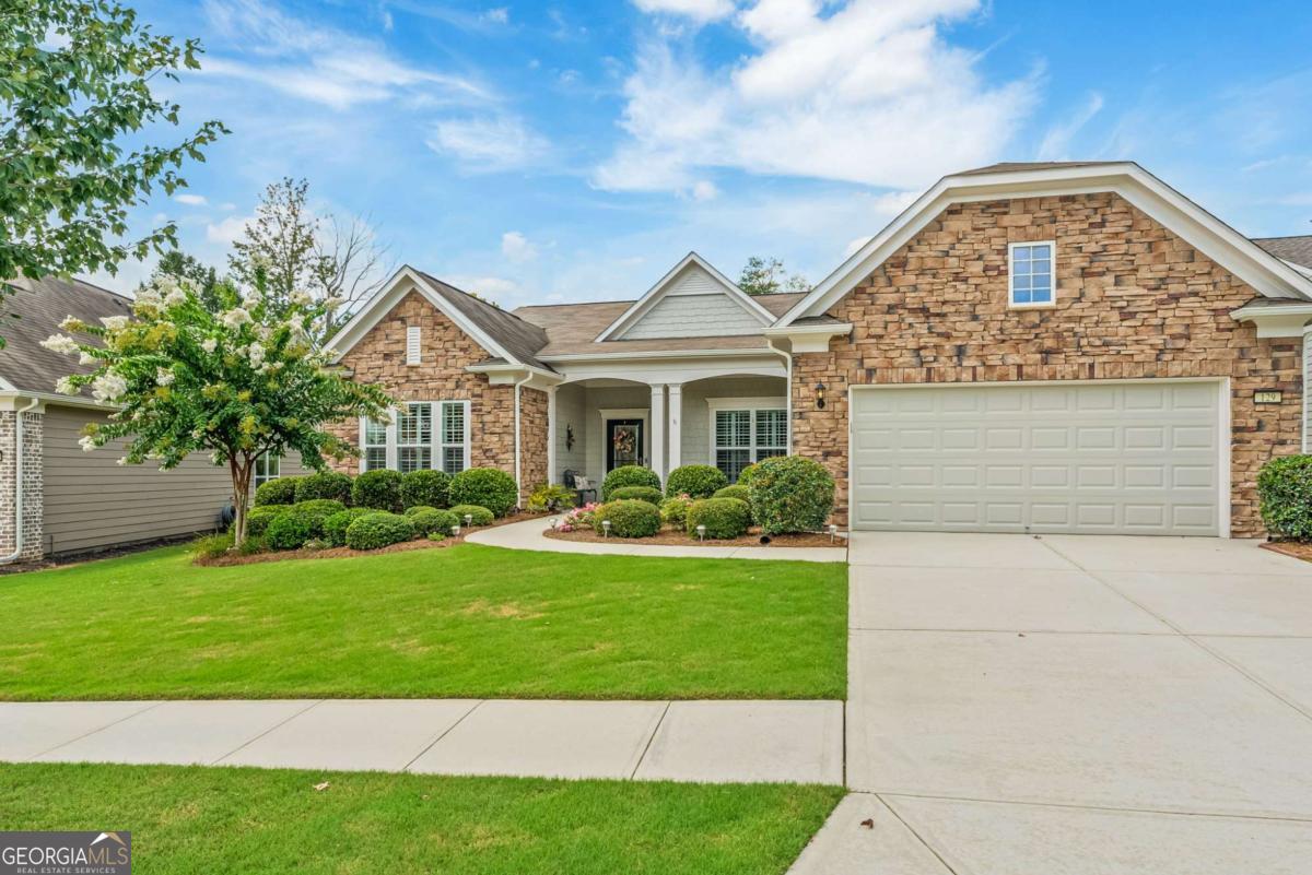 If you're searching for a highly sought-after floor plan in one of the country's most affordable Del Webb active adult communities, look no further. This well-maintained, one-level Dunwoody Way in Sun City Peachtree is it! Conveniently located within the community, this home features a full stacked stone front exterior (no longer offered by the builder) and a nicely manicured lawn with beautiful landscaping. Stepping inside, the foyer flows easily into the open living layout which includes a great room, dining room and chef's kitchen where large gatherings can mingle with ease. Plantation shutters provide style and privacy throughout the home. Off the foyer, glass French doors grace a flex room which may be used for formal living or an office. The primary bedroom features a tray ceiling, en suite and a large built-in closet. Completing the bedrooms are an en suite guest bedroom and a third bedroom with an adjacent full bathroom. The 2-car garage has epoxy floors and ample space with a 4-foot-long extension, overhead floored attic space, and enclosed shelving that will remain with the home. If you love the outdoors, that's where this one over other options! The backyard is a private, restful retreat featuring THREE outdoor living spaces: a screened lanai, a covered patio AND an oversized open patio surrounded by additional landscaping and backed by private community property. But life here is about more than your home. Come be a part of a community that is the epitome of comfort surrounded by fun, loving, diverse and caring neighbors who quickly become friends. Your HOA fees include access to a 45,000-square-foot amenities center with a state-of-the-art fitness center, indoor and outdoor pools, pool tables, library, business center, game room, ballroom even a theater. Outside, you'll find 6 bocce ball, tennis (4 Clay / 2 Hard), one basketball and recently expanded pickleball to 11 courts. Also for your enjoyment are walking trails, a softball field, dog park, and playground. If you're a golf enthusiast, gain access an 18-hole course within the community with an additional membership fee. Since most yard work is included in HOA fees, you'll always have time for the fun stuff! With 45+ interest groups and a full-time activities director, boredom simply isn't an option. Golf cart friendly and designed for active adults, SunCity Peachtree is one of Georgia's best kept secrets. What are you waiting for? This home is a must see! Schedule an appointment today!