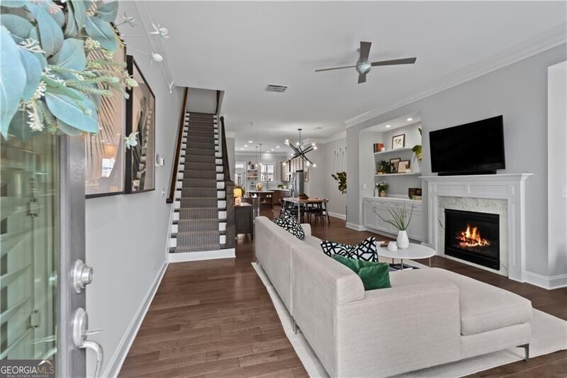 Directly across from Blackburn Park and one block from the brand-new Publix, this Brookhaven townhome delivers both location and luxury in the Gated Community of Parkhaven. The main level offers an open floor plan anchored by a fireside living room with marble surround, built-ins, and floating shelves. The chef's kitchen features stained 5-piece shaker cabinetry, quartz countertops, a stone and glass backsplash, Whirlpool stainless-steel appliances, and an oversized island. A spacious dining room comfortably seats 12+. The primary suite overlooks Blackburn Park and boasts a Custom California Closet system, tray ceiling, and spa-quality bath with dual vanities, a freestanding soaking tub, and a frameless shower with dual showerheads. The terrace level stands out with an oversized light-filled bedroom or flexible second living space that flows seamlessly onto a private front patio-perfect for morning coffee, evening cocktails, or entertaining. Together with the back deck off the kitchen, the home provides multiple outdoor living areas. Enjoy the ultimate convenient lifestyle with restaurants, bakeries, and shops just outside your door, plus award-winning public schools and top-rated private schools, including Marist and St. Martin's Episcopal, just minutes away. Additional features include hardwood floors throughout terrace and main living levels, plantation shutters, updated lighting, Tesla charger, Custom California Closets and en suite bathrooms in each bedroom, and built-in mudroom cabinetry.