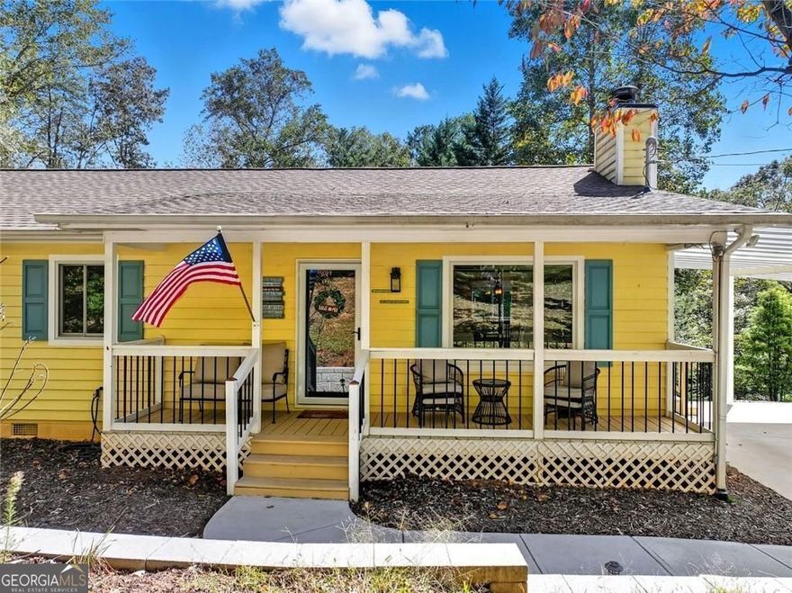 Get a 1/0 rate buy-down for the first year using the Seller's preferred lender! Lake days start here, just steps from your door, a no wake pristine cove with year round access to deep water and a two-story Wahoo party dock are ready for sunset swims, weekend gatherings, and fireworks-filled nights. Paddle across the cove to your own sandy beach or cruise out to the big water in minutes. The gentle, shaded path to the dock makes every trip easy, whether you're hauling picnic gear or just your morning coffee.  Inside, the layout is as practical as it is welcoming. A sun-filled common area sits just off the primary suite - ideal for lake lounging, hosting guests, or creating a quiet retreat. The living room anchors the home with a wood-burning fireplace and flows into the open dining area and kitchen, complete with a pantry and direct access to both full bathrooms.  The primary bedroom features its own private bath and closet, tucked away from two additional bedrooms, each with closet space and quick access to the hallway bath.Storage is thoughtfully designed throughout, featuring a convenient bonus closet near the entry and a built-in pantry in the kitchen.  Out back, a patio wired for golf cart charging includes a dedicated cart pad-because you'll want a quick ride down to the dock or around the quiet neighborhood. You're less than ten minutes to local barbecue, North Georgia outlets, and five nearby wineries. When needed, Atlanta's airport is under an hour away.  Whether you're hosting a weekend crew or escaping the everyday, this is lake life made easy-and it's waiting for you.