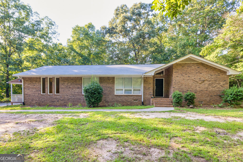 Tucked away on a quiet 2 ACRE lot is this lovely RANCH home offering convenience and privacy with NO HOA! Mature shade trees, long driveway, and plenty of space to park your toys. Spacious living and dining rooms flow effortlessly into the family room, making it easy to mingle no matter the occasion. Curl up by the beautiful white brick fireplace as we welcome those cool months ahead. The galley kitchen shows off white cabinetry, wall oven, cooktop, and plenty of counter space to prepare your favorite meals. Just off the heart of the home is a large screened deck where you'll enjoy the fresh air without worrying about pests. Generously sized bedrooms and a HUGE BONUS ROOM that could be an extra bedroom or the ultimate media and game room. Off the bonus room is a covered rocking chair front porch. Imagine sipping your morning coffee as you overlook your private and serene property with the great outdoors at your fingertips. This home may be just outside the hustle and bustle, but it is conveniently located near schools as well as many shopping and dining options. Short drive to the Atlanta Motor Speedway, golf courses, local trails, parks, and community events for the whole family.