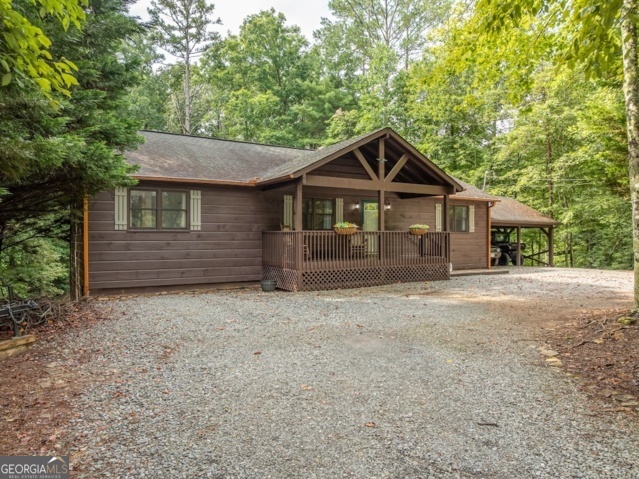 Beautiful 4-bedroom, 3-bathroom ranch home with finished terrace level sits on a spacious 1.52-acre lot, offering the perfect blend of comfort and entertainment. The eat-in kitchen boasts new solid surface countertops, new cabinet faces, new sink and stainless steel appliances, perfect for cooking and gatherings. The terrace level features a bedroom, bathroom, kitchenette, and a versatile space ideal for guests. It makes a fantastic game room/gathering area, perfect for game day with the two built in bars. Relax and enjoy outdoor living with a covered front porch, a covered back porch, and an open-air grilling deck. The large yard provides ample space for outdoor activities, while the semi-circle driveway ensures easy in-and-out access. Additional features include refinished floors on main level, a tiled primary bathroom shower, new terrace level flooring, 2-car carport in a gated resort community that includes river access, fishing lake, swimming, tennis, pickleball, basketball, a fitness center, clubhouse, arcade/game room and much more. Conveniently located close to town, this home offers both tranquility and accessibility.
