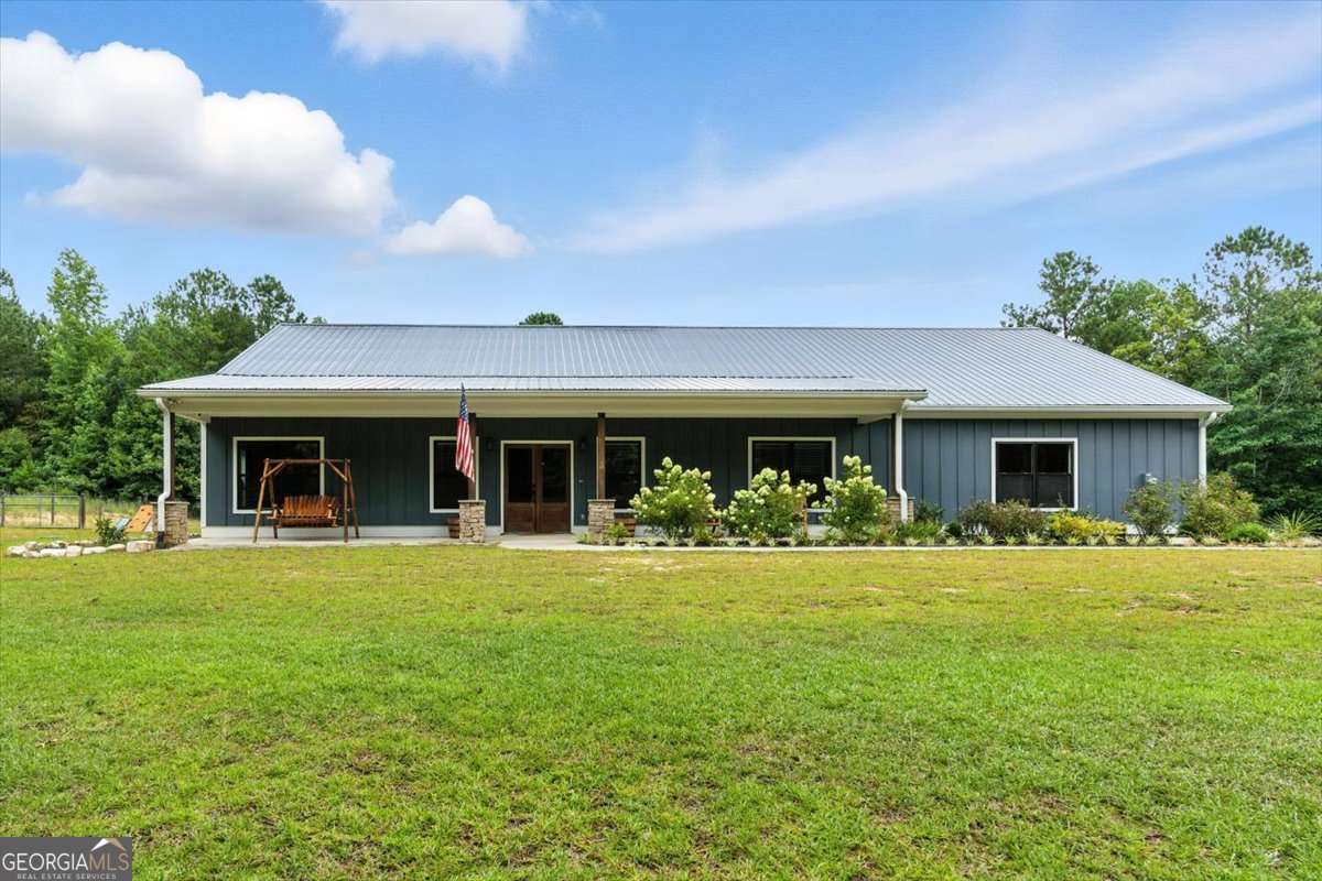 Welcome to 1235 Williams Rd-a true hidden gem in North Paulding offering peaceful seclusion, modern conveniences, and endless possibilities on 10.5 private acres with a gated entrance, dedicated RV parking space with an electrical hookup, making packing, unloading, or accommodating out-of-town guests easy and convenient. Outdoor lovers will appreciate private access to Pumpkinvine Creek, perfect for fishing or playing in the water right on your own land. Built in 2020, this stepless ranch home features 3 bedrooms, 2 full bathrooms, and a large flex room with a wet bar perfect for a home office, game room, or oversized dining space. The bright, open-concept layout centers around a stunning kitchen with a huge island, granite countertops, stainless steel appliances, and a stacked stone fireplace. Enjoy the practicality of a large laundry room with its own sink, perfect for pre-soaking or quick clean-ups. The primary suite offers plenty of room for large furniture and includes a luxurious en suite bathroom with an oversized tile shower, dual-sink vanity, and a walk-in closet. Enjoy the efficiency of a tankless water heater and the peace of mind that comes with filtered well water. No need to worry about internet access-fiber and high-speed internet service is already available! Step out to the screened back porch and enjoy views of your fenced backyard with frequent visits from deer, turkey, and other wildlife. The oversized 10' garage doors provide ample space for trucks, recreational vehicles, or storage. Whether you're looking for complete privacy, building a mini farm, or a property ready for entertaining-this one checks all the boxes.