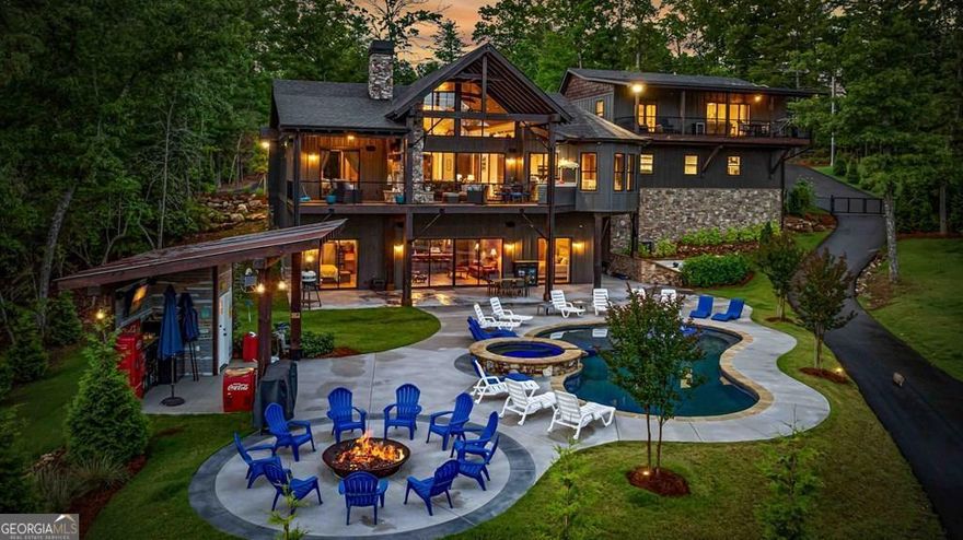Indulge in the epitome of luxury living at this extraordinary lakefront sanctuary! A grand entrance welcomes you with a majestic floor-to-ceiling stone wood-burning fireplace & intricate architectural & rustic details that frame panoramic views of Lake Blue Ridge & the majestic mountain landscape. Enter the heart of the home, where a gourmet kitchen featuring Viking appliances, an enhanced butler's pantry, & unmatched attention to detail await. With six luxurious ensuite bedrooms spread across both levels of the main residence, each guest is pampered with unmatched comfort. The primary suite is a haven of extravagance, boasting a zero-entry tile shower, heated flooring, a lavish jetted tub, and the ultimate touch of refinement - a bidet for unparalleled luxury. Enjoy entertainment without limits in the lower level, where a full wet bar seamlessly transitions to an outdoor kitchen, a serene pool, a rejuvenating hot tub, a delightful pool house with a half bath, and a captivating fire pit area. For additional accommodations, the three-car garage hosts a sophisticated 2-bedroom, 2-bathroom apartment above, perfect for guests or staff quarters. Live the pinnacle of luxury with premium amenities such as a whole house generator, a private fenced backyard catering to both privacy and pet-friendly needs, and a newly installed double-decker Wahoo boat dock complete with a 2022 Barletta 24' pontoon boat. Additionally, a full RV hook-up including 50 amps, water, and sewer connections adds further convenience and versatility to this remarkable property. Offered fully furnished, this residence presents a compelling opportunity as a successful short-term rental, blending unparalleled comfort with exceptional investment prospects. With a host of exceptional extras included by the homeowner, this home promises a lifestyle of unrivaled opulence and sophistication that surpasses all expectations.