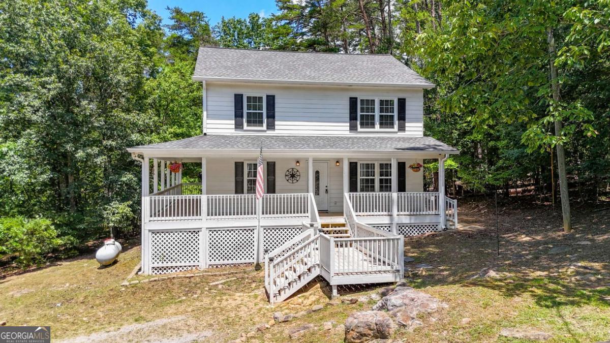 Fall in love with the classic farmhouse feel of this quaint 3-bedroom, 2.5-bath home nestled on a peaceful 1.89 acre lot. From the moment you step onto the inviting wrap-around porch, you'll be drawn into the warmth and charm of country living. All three bedrooms and two full bathrooms are conveniently located upstairs, while the main floor offers a welcoming layout with a half bath and a spacious laundry room. The kitchen boasts white cabinetry, stainless steel appliances, and tile backsplash. Enjoy a private, wooded backyard perfect for relaxing. The septic tank has just been pumped, and the windows were replaced five years ago, offering added peace of mind. Located in a quiet community with lake access through the HOA, this home offers the perfect mix of tranquility and recreation. Don't miss this cozy gem-ideal for those seeking a peaceful lifestyle with modern comforts and timeless country charm.