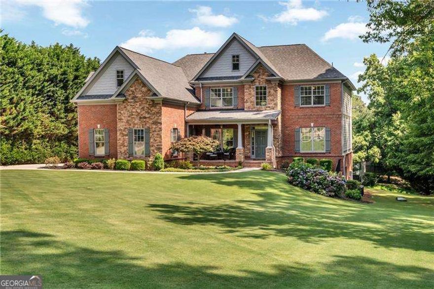 **UNBELIEVABLE PRICE!!**Custom-Built Lake Lanier Retreat - A Builder's Personal Masterpiece**    Welcome to a perfectly maintained brick and stone home on the shores of Lake Lanier, built and owned by the builder himself-where quality craftsmanship meets lakeside living. Every inch of this home was thoughtfully designed with expanded room sizes, custom accent walls, heavy trim, and attention to detail in every room.    Step outside and launch your kayak, cast a line, or simply relax by the water-this lush one-acre property offers direct lake access right from your backyard. A spacious front porch is the perfect spot to unwind as deer graze nearby, and the oversized back deck sets the stage for peaceful sunset dinners. Gather around the fire pit and soak in the serenity of your private retreat.    Inside, the home impresses with a two-story family room filled with natural light, a warm keeping room off the large kitchen, and a generous breakfast area perfect for casual mornings. The kitchen is a dream with abundant cabinetry and workspace. Main level living includes a bedroom and full bath, an office with built-ins, and a formal dining room for entertaining.    Upstairs features large secondary bedrooms, a bonus/media room ideal for movie nights or play space, and a stunning owner's suite with a completely remodeled bathroom and custom closet shelving.    An unfinished basement offers room to grow or customize. The home also boasts a newer roof, new interior and exterior paint,  300-amp electrical service, irrigation system, speaker system throughout the home, new flooring and more!!! AND, it is just seconds from a boat ramp, park, playground, and picnic pavilions.    This is more than a home-it's a lifestyle!