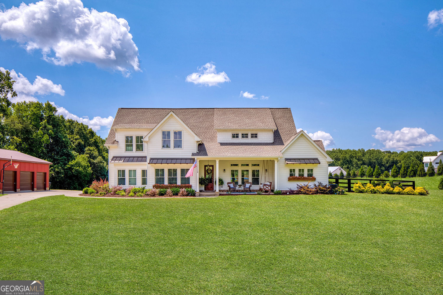 This is the one you've been waiting for! Welcome to your Milton farmhouse dream home tucked into a scenic pocket just inside Cherokee County, with effortless access to Milton, Cumming, Avalon, and Canton. Set on 3.86 picture-perfect acres, this timeless white modern farmhouse, custom built in 2022, offers a lifestyle that feels like a vacation every day. From the charming front porch to the beautifully designed interior, every detail invites you to slow down and savor life. The open floor plan is warm and inviting, featuring hardwood floors throughout the main level and expansive windows that fill the space with natural light. The fireside family room with 10" ceilings opens directly to your private poolside retreat and a stunning island kitchen perfect for gathering and entertaining. The kitchen is a true showstopper, featuring quartz countertops, a farmhouse sink, tile backsplash, 5-burner gas range, double ovens, built-in microwave, and a spacious walk-in pantry. Just behind it, discover an incredible butler's pantry with a stone accent wall, ample cabinetry, a sink, and space for a beverage fridge. The kitchen flows effortlessly into a sun-filled dining area, both accented with stained shiplap ceilings for extra character. Need a quiet place to work? A tucked-away main floor office behind the butler's pantry offers privacy and focus. Even laundry is elevated here located in a stylish mudroom off the kitchen, complete with herringbone tile floors, shiplap walls, storage, and direct access to both the driveway and garage. The main-level primary suite is your personal sanctuary, featuring a fireside sitting area, private access to the covered patio and pool, and a spa-like ensuite bath with soaking tub, oversized shower, dual vanities, and a custom walk-in closet. Step outside and you may never want to leave. The covered back porch is ideal for grilling with family and friends, quiet mornings with a cup of coffee, or date nights by the pool. The saltwater heated pool includes a built-in spa and bar stools, with sweeping views of your peaceful acreage truly a vacation-at-home experience. Upstairs, the layout is both smart and spacious. A large landing area with a craft nook, two bedrooms with a shared bath and double vanity, and a third oversized bedroom currently used as a media/game room (easily convertible into two bedrooms) complete the upper level. This bonus room also features a large full bathroom and there is a walk-in attic storage upstairs as well. Outside, a detached barn-style building currently serves as a car workshop with three garage bays and a separate entry door perfect for conversion into a studio, barn, guest suite, or multigenerational living space. The land is just as special: mostly level, cleared, and partially fenced for horses, with a small wooded area for added privacy. It's the perfect blend of usable space, peaceful surroundings, and future possibilities. This home delivers on every level: modern luxury, thoughtful design, room to grow, and a location that keeps you close to everything yet feeling like you're a world away. Bring your vision. Bring your horses. Welcome home to everyday vacation living.