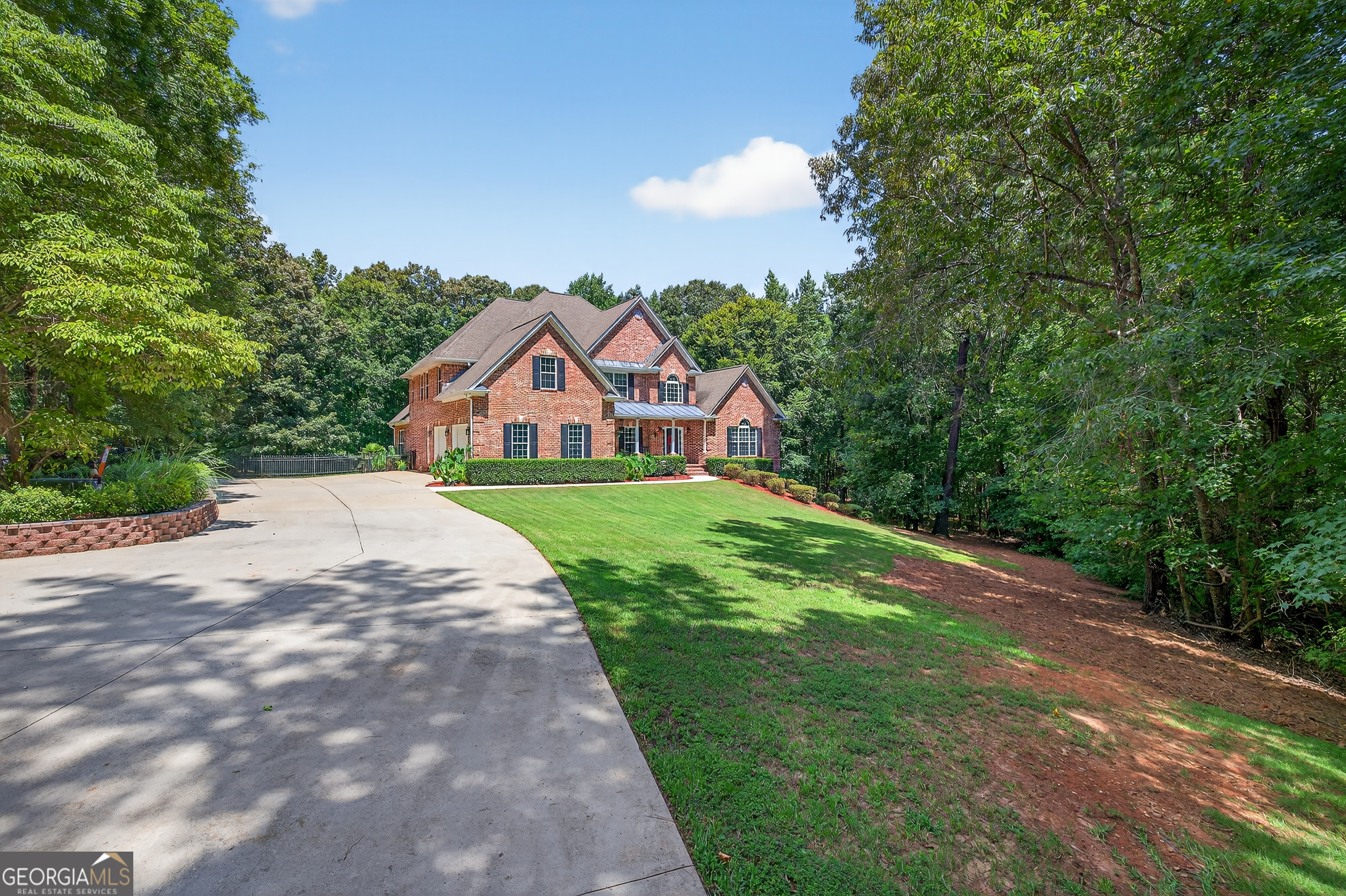 Welcome to 1050 Cedar Grove Drive in Buckhead, GA - a stunning all-brick estate set on approximately 25+/- acres of pristine hunting hardwood land, complete with an in-ground saltwater pool and endless possibilities for recreation and relaxation. This expansive 8-bedroom, 5-bathroom home offers a luxurious master suite and guest bedroom on the main floor, alongside a chef's kitchen with an eat-at island, keeping room, breakfast room, formal dining, and vaulted family room. Upstairs features 3 additional bedrooms and 2 full baths, while the finished basement provides a full in-law suite with 3 bedrooms, a bathroom, kitchenette, game room, theatre, and sunroom. Outdoor enthusiasts will love the hunter's paradise with deer stands, trails, and thousands of trail camera images of trophy deer and turkey. The property also includes an estimated 5000+ sq ft heated and cooled shop with a kitchen, laundry, and bathroom ideal for car collectors or hobbyists plus additional covered storage for RVs and equipment. Enjoy serene views from the screened porch overlooking the fenced backyard and pool. An additional 25+/- acre tract is also available next door at 1070 Cedar Grove Drive.