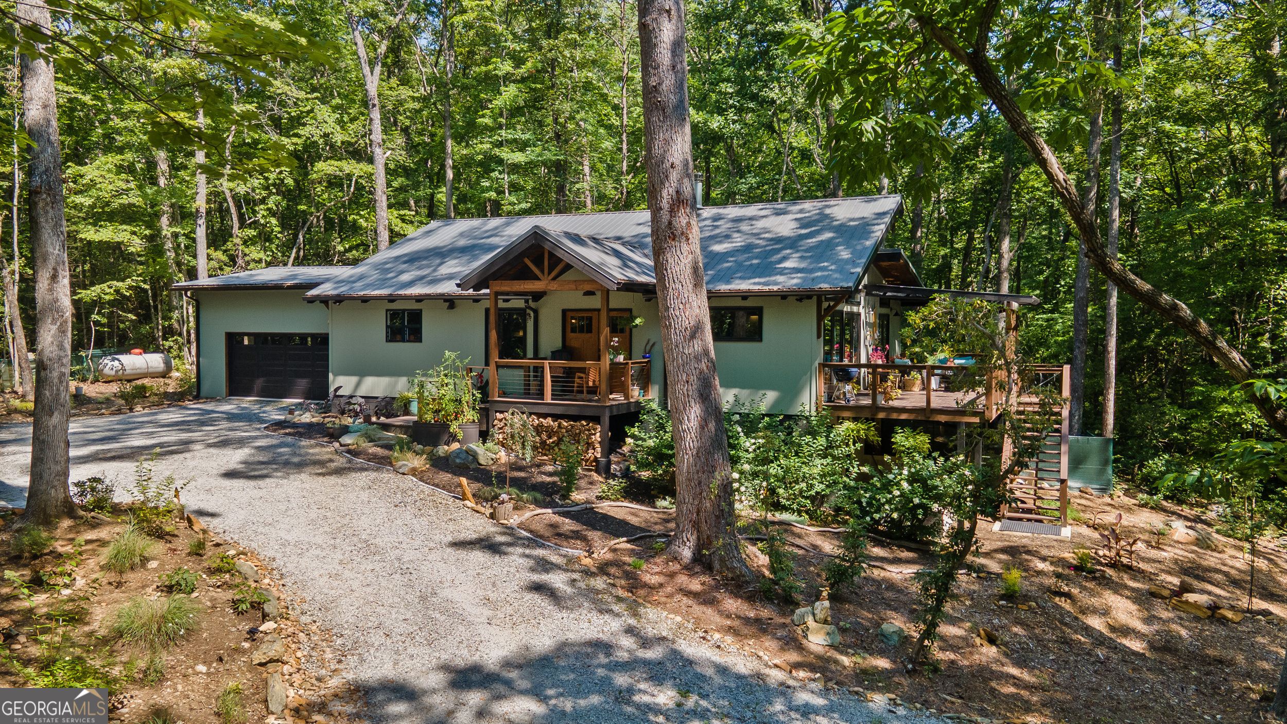 Welcome to this beautifully crafted 2-bedroom, 2-bath home built in 2022, nestled on 1.33 private acres surrounded by mature woods and flourishing fruit trees. Inside this newer construction home, you'll find vaulted ceilings, an open floor plan, and a cozy wood-burning stove that adds warmth and charm. The bathrooms are a true highlight, featuring custom tile work that adds elegance and character. The spacious kitchen flows effortlessly into the living area, making it perfect for everyday living or entertaining. Step outside the family room to relax on the oversized porch overlooking the private yard and the always-flowing creek that runs through the property. An oversized two-car garage adds convenience and ample storage. Don't miss your chance to own a slice of North Georgia paradise-just a short drive to Lake Burton, hiking, and all the outdoor recreation the area has to offer.