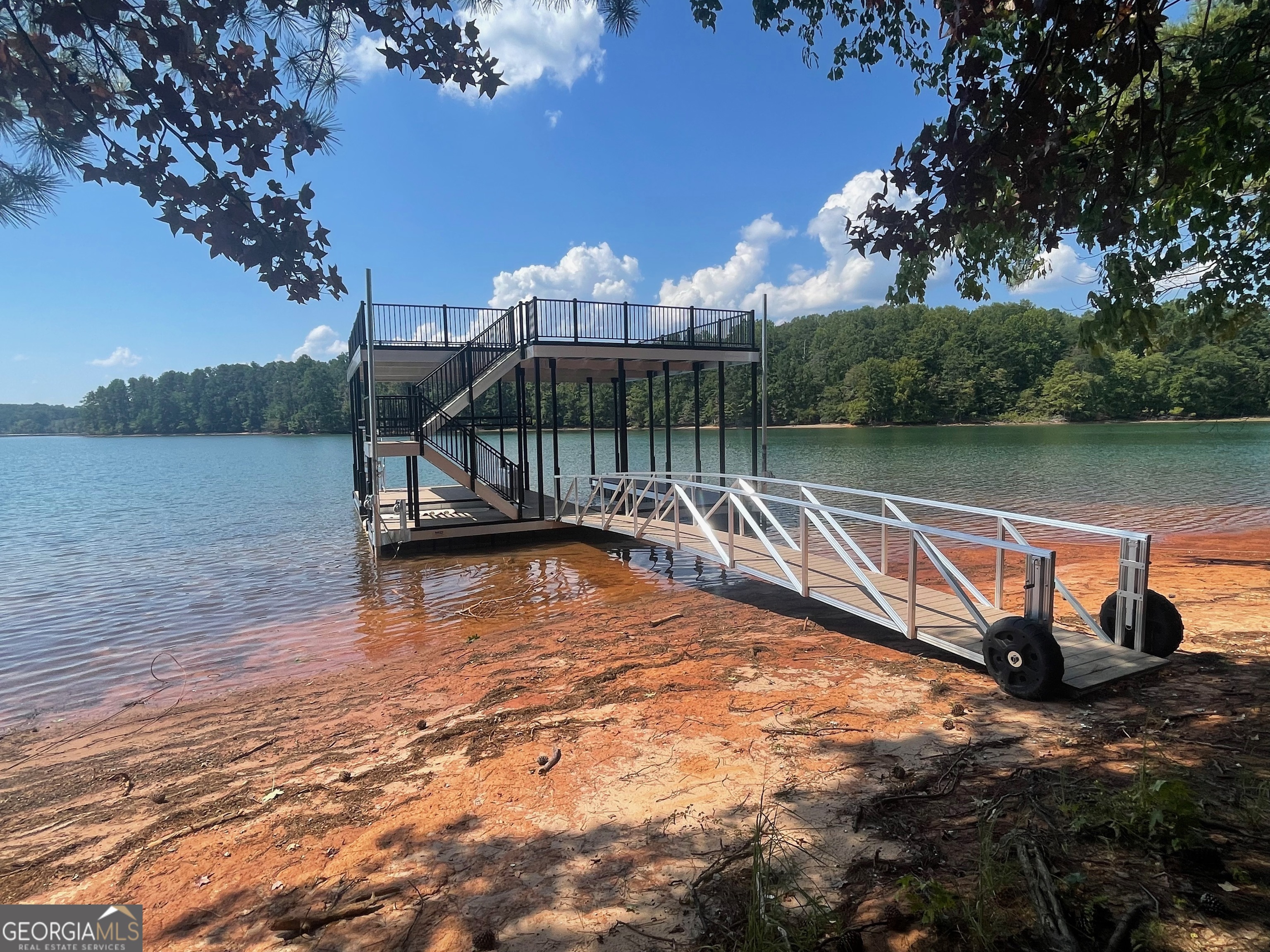 Incredible opportunity to build dream home on Lake Lanier. Only 2 lots remaining with grass to the water and mow permits, open view and rare gentle slope to the water. Located on a private road off Browns Bridge Rd. Just 3 miles from 400 in the coveted 6 mile cove. Very close to the new East Forsyth High School. This lot also has a brand new two level 32 by 32 Martin Dock.