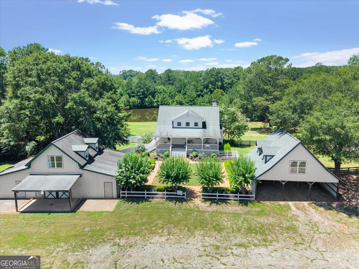Escape to your private sanctuary in desirable north Morgan County. A spectacular +/- 57-acre estate offering a perfect blend of luxury, functionality, and charm. Traveling down the winding driveway, lose yourself in the scenery filled with beautiful, improved pastures and million-dollar views. Upon arrival at the home, discover a custom-built 3,550-square-foot farmhouse offering a delightful mix of refined and rustic style. A finished terrace level further enhances the home's versatility, offering an area that can easily be utilized as a family game room space, a perfect spot for homeschooling, a man cave, or an amazing playroom, to name a few! Breathtaking views from several locations in the home will enable you to drift away from reality. This 4 bedroom, 3 bath elegant home features hardwood floors throughout and a feeling of warmth as soon as you enter. An open floor plan, including living and dining areas, easily creates an ideal environment for entertaining or spending time with family. Have a nice cup of coffee on the sun porch and gaze over the gorgeous stocked pond! The gourmet kitchen is a chef's dream, boasting soapstone and marble countertops, a Wolf range, and a well appointed walk-in pantry. Plentiful seating and the spacious design ensure that when hosting for the holidays and celebrations, everyone will be comfortable. Step outside and immerse yourself in the serenity this one-of-a-kind property offers, complete with a 1.5-acre spring-fed stocked pond - a tranquil spot for fishing and relaxation- a heated saltwater pool great for year-round enjoyment, a 40x60 barn with 2 stalls, and a tack room with adequate space to expand. Among the extras are a custom chicken coup, raised bed gardens, and vibrant fruit trees adding to the beauty of this stunning property. Parking and storage are ample, with a detached three-bay garage designed to enhance the aesthetic charm offered by this property. The 24 x 44 outbuilding with a studio apartment is great for guests and a great opportunity to open a business. Formerly, this farm was a cheese-making facility, and the outbuilding where the cheese was made is built to the Department of Agriculture specs, lending itself to easily become a vibrant farm-to-table food production operation once again. Loaded with possibilities, this property can be your next home, a sportsman's paradise as it has an abundance of wildlife, a working farm, an equestrian property, or a place to house your dream of a farm-to-table business facility! A combination of two parcels are being sold together. The home, barn, and outbuildings are situated on 21.28 acres. A gently rolling 36.52-acre pasture that is a separate parcel, complete with a well and power, contribute the possibility of building another home or structure. A rare find indeed! Come and experience this tranquil estate offering unparalleled privacy while remaining conveniently located minutes from downtown Madison, 25 miles from Athens, and approximately 60 miles from the Atlanta Airport. Schedule your viewing today!