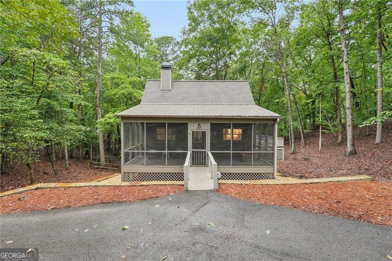 Charming, Fully Remodeled 2BR/2.5BA Mountain Cabin Retreat Welcome to your dream mountain getaway! This beautifully remodeled (2023) 2-bedroom, 2.5-bath cabin perfectly blends modern comfort with rustic charm. From the rocking chair front porch to the light-filled great room, every detail has been thoughtfully designed to create a warm and functional retreat. Step inside and be greeted by an open, airy great room featuring a floor-to-ceiling stacked stone fireplace, complete with a mantle reclaimed from an antique Amish barn. The great room flows effortlessly onto a private deck, which leads down to a massive two-level entertainment deck with gazebo, perfect for hosting family and friends under the stars. Too many upgrades/remodeling features to list here. Complete list is in the home. Interior Highlights: . Heated floors throughout all levels, including hallways and bathrooms . Wood ceilings, oversized baseboards, board & batten accents. . Custom and recessed lighting, lighted stairwells, and large windows throughout . New AC system and ductwork Main Level: . Great room with floor-to-ceiling stacked stone fireplace and Amish barn wood mantle . Custom kitchen w/ Big Chill appliances, quartz countertops, farmhouse sink, iron hardware, and under-cabinet/glass lighting Upstairs Bedroom Suite: . Renovated bath with quartz countertops, walk-in shower (distressed subway tile + glass door), custom lighting Terrace Level Primary Suite: . French doors to oversized private deck and screened porch . Spa-like ensuite w/ double sinks, quartz counters, pebble-floor walk-in shower, and custom mirrors/faucets Outdoor Features: . Screened front porch & new screened back porch off the master . Upper deck tiled to match interiors, leading to oversized lower deck . Gazebo (pre-wired & prepped for hot tub) . Large fenced backyard with two gates . New stone retaining walls along driveway and side of home. . 50 amp EV plug-in . Circular driveway for easy access . Electrical conduit ready for future garage/carport lighting