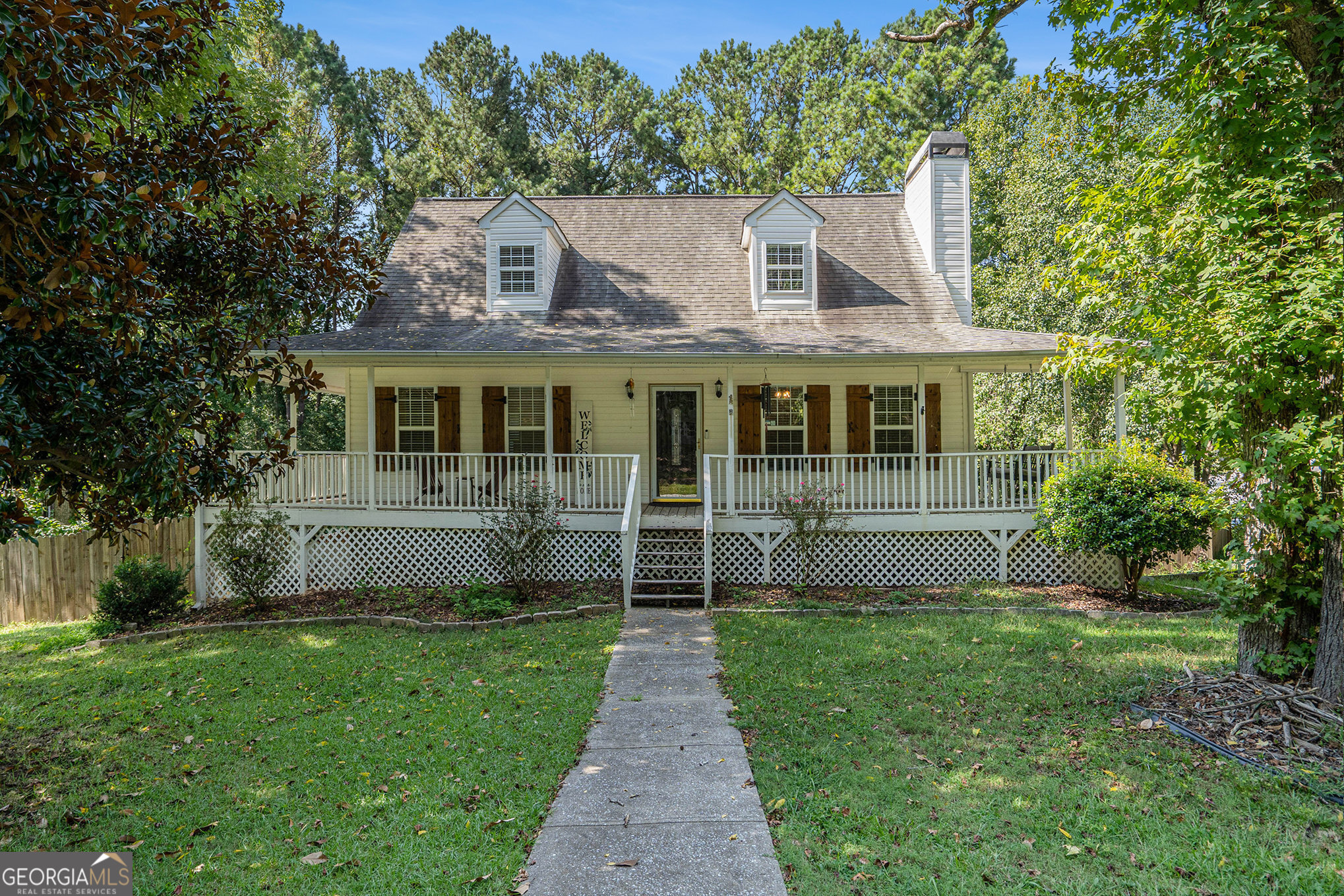 Welcome Home to the southern charm of a Cape Cod! Wrap around front porch is perfect for your morning coffee or evening chats. REAL Hardwood floors throughout the main level, recently refinished in the living area and kitchen. Cozy kitchen with a practically new refrigerator that comes with the property. Large primary bedroom with door to wrap around porch and bath with separate tub and shower, and huge closet with cedar plank floors. 2 generously sized bedrooms upstairs, along with a full bath and extra storage closet. Don't forget the basement with a finished room (could be a media room!), and a workshop room. Large corner lot with wood-fenced backyard. Excellent North Paulding High School District! Plus No HOA! Don't miss this cute-as-a-button home! Upstairs bedrooms to be painted a neutral color in the coming days.